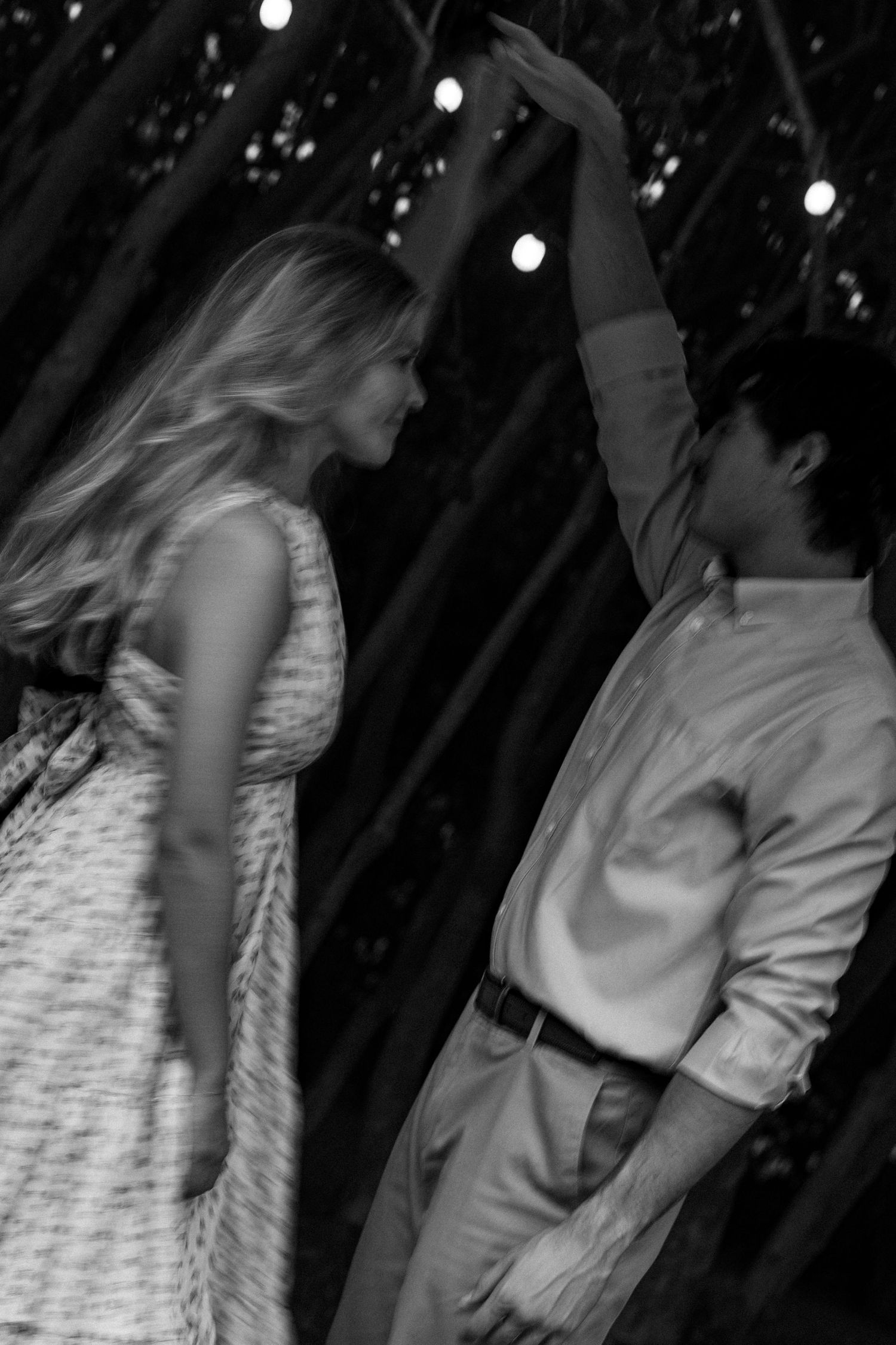 Motion-blur dance sequence captured at night under outdoor lighting.