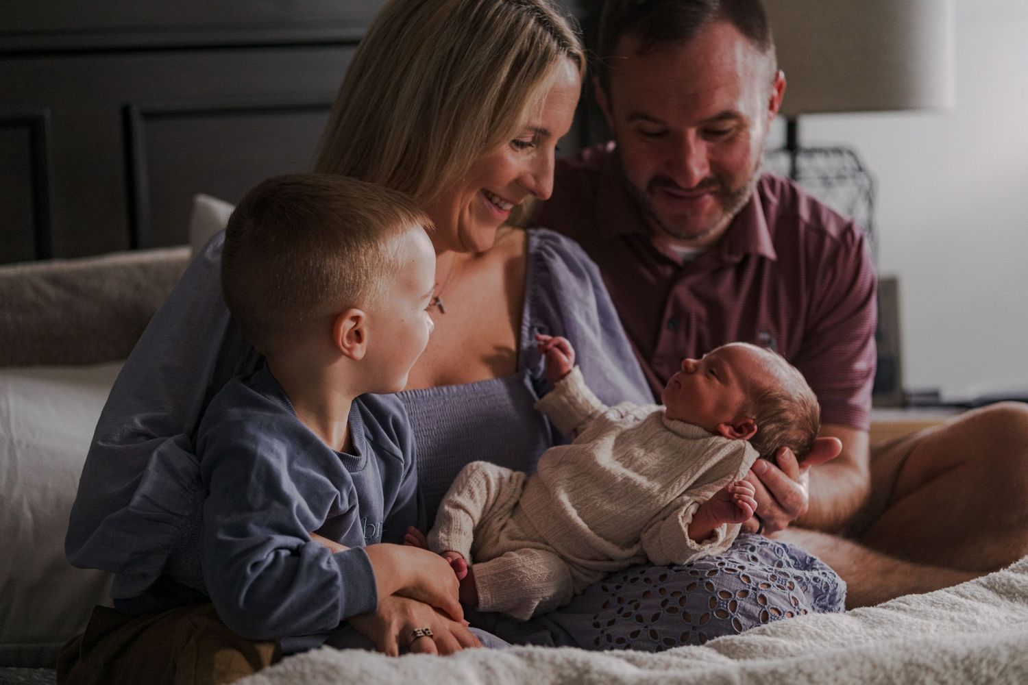 Intimate family moment captured on a couch as they share joyful expressions together.