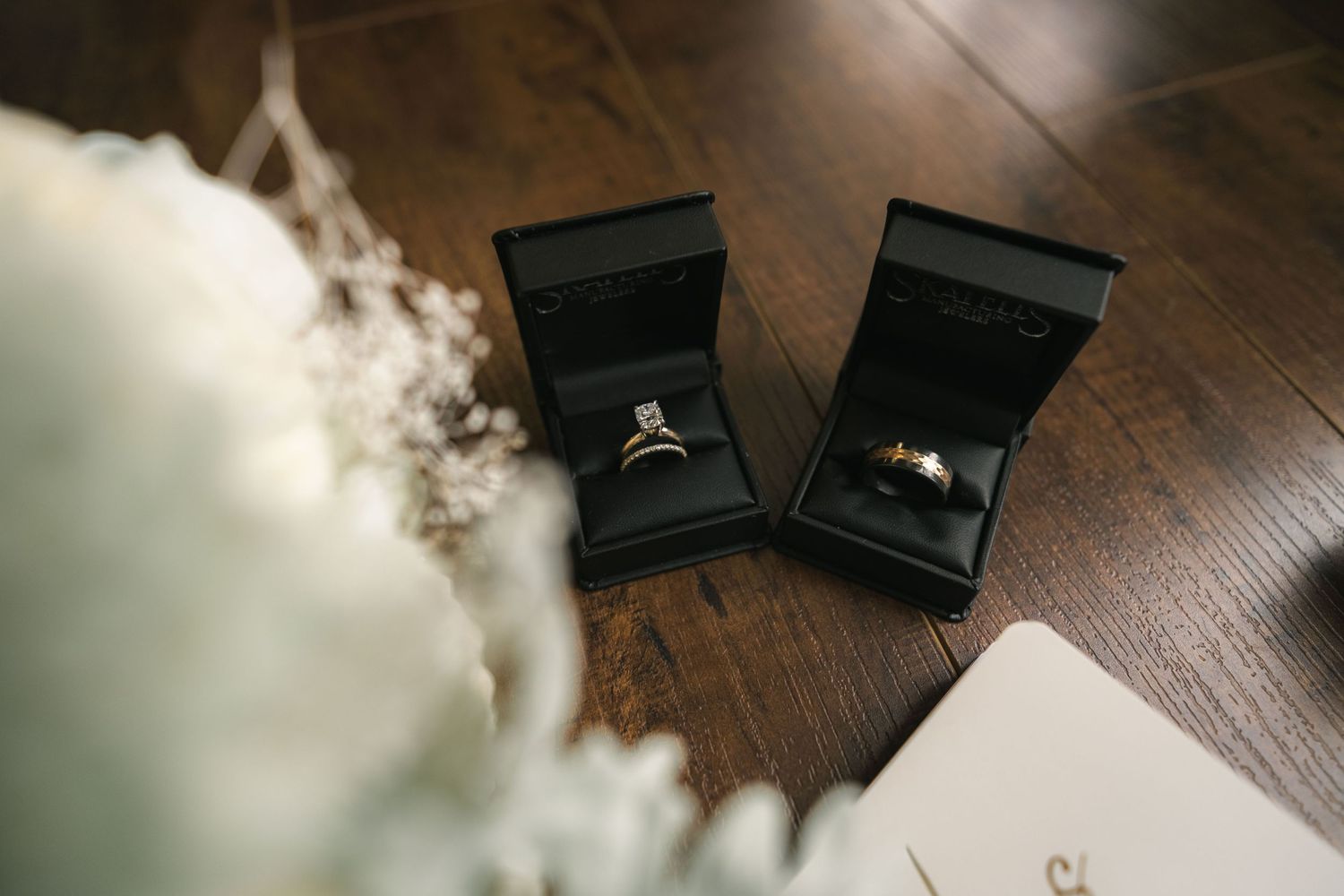 Wedding rings displayed on a dark wooden surface with soft focus.