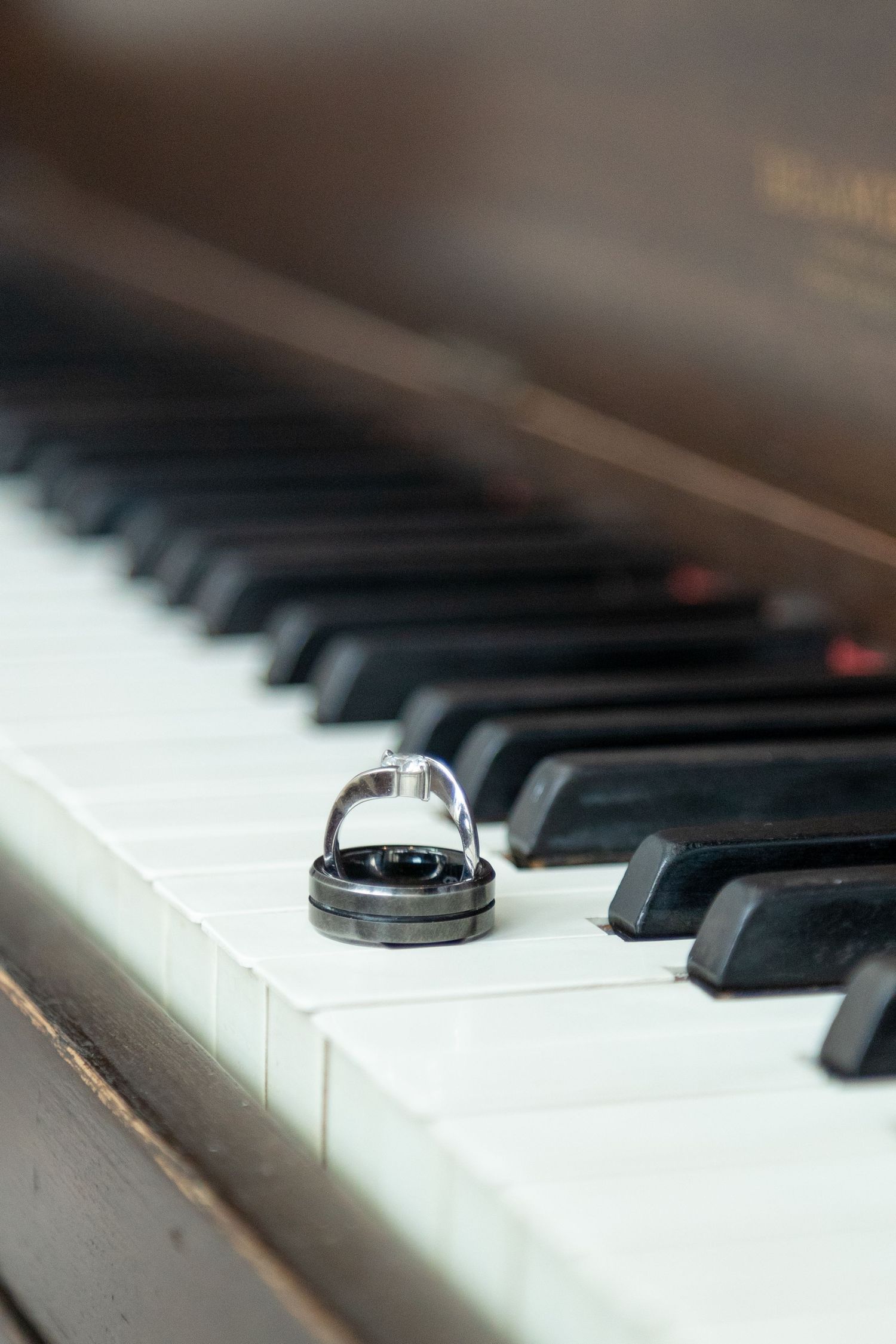 Romantic wedding rings resting on piano keys, symbolizing love and harmony—perfect for elegant weddings and timeless celebrations.