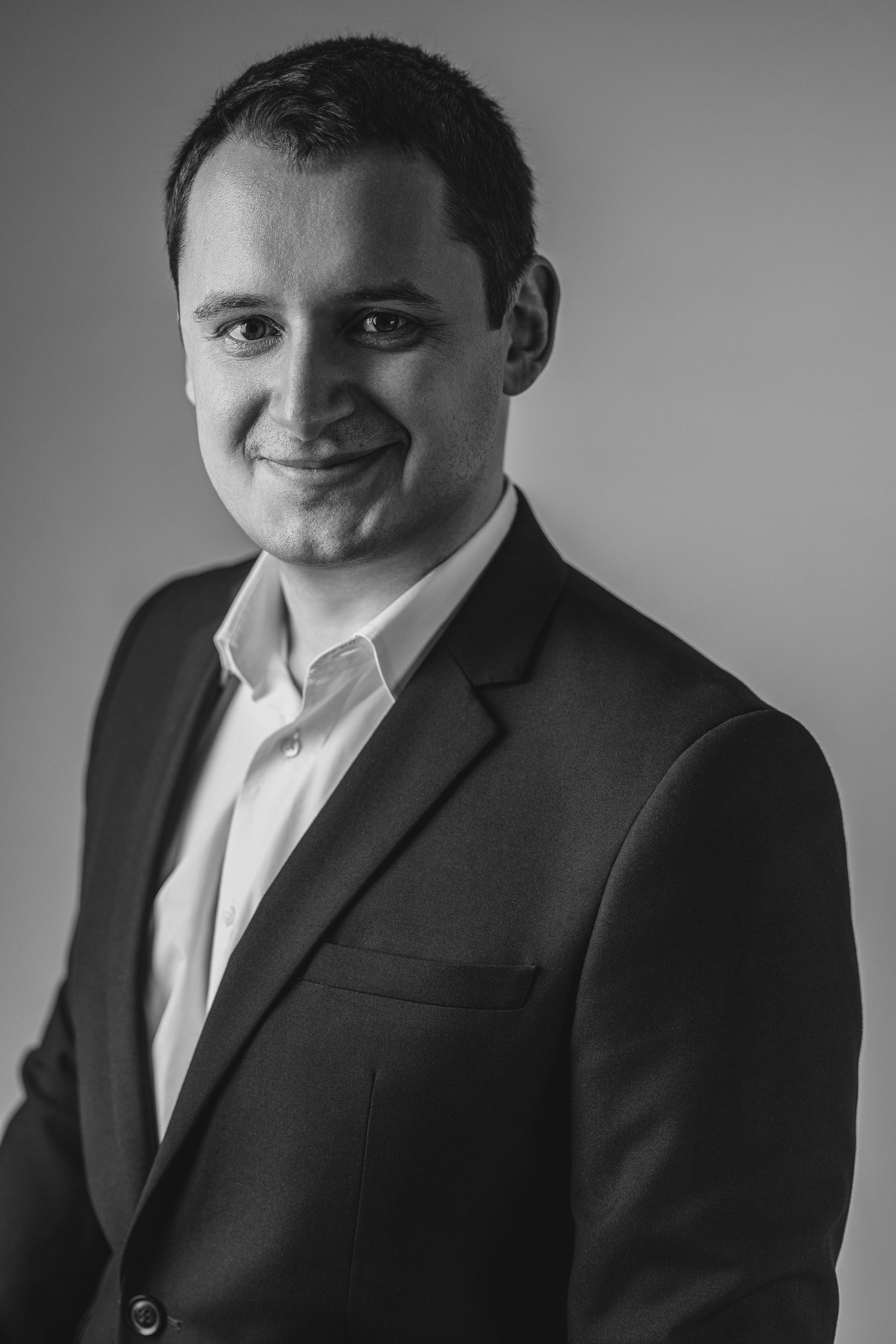 Black and white corporate headshot of a young man in a jacket, Brussels business photographer Liene Boutens