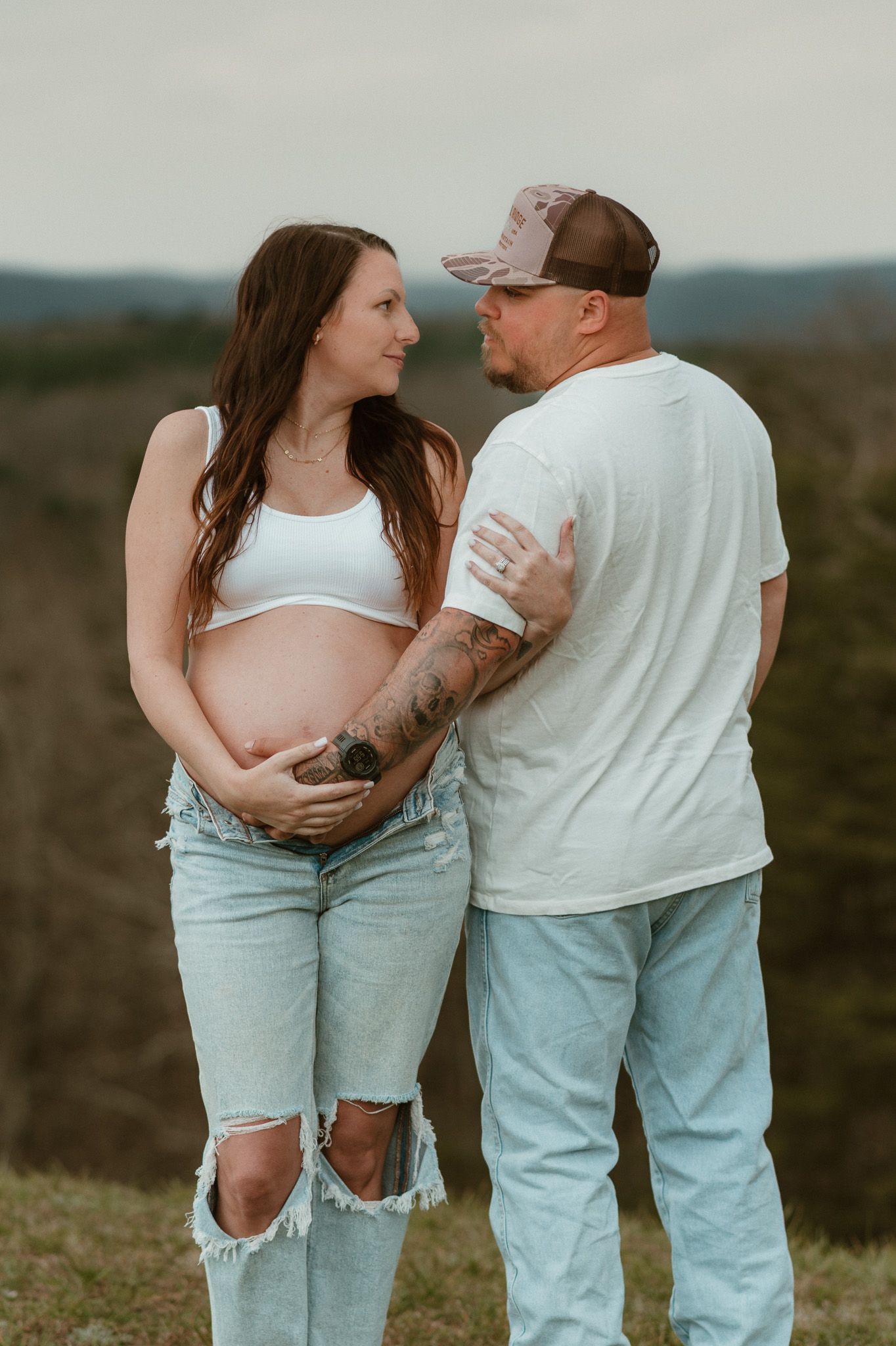 Expecting couple side by side with him looking out holding her bump during maternity session on raccoon mountain in chattanooga tn, overlook