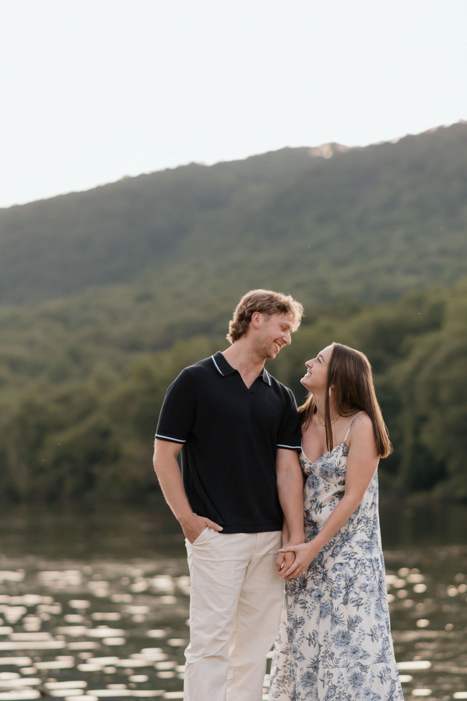 Couple looking at eachother holding hands after surprise proposal near river and raccoon mountain during engagement session