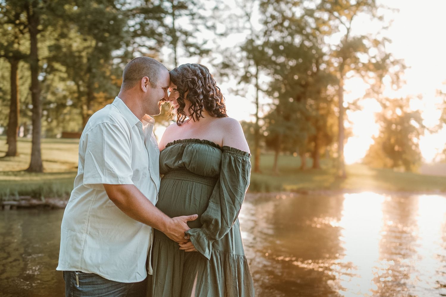 Natural light maternity photo of expecting parents standing together, hands on baby bump, sharing a quiet moment outdoors in Hixson, TN
