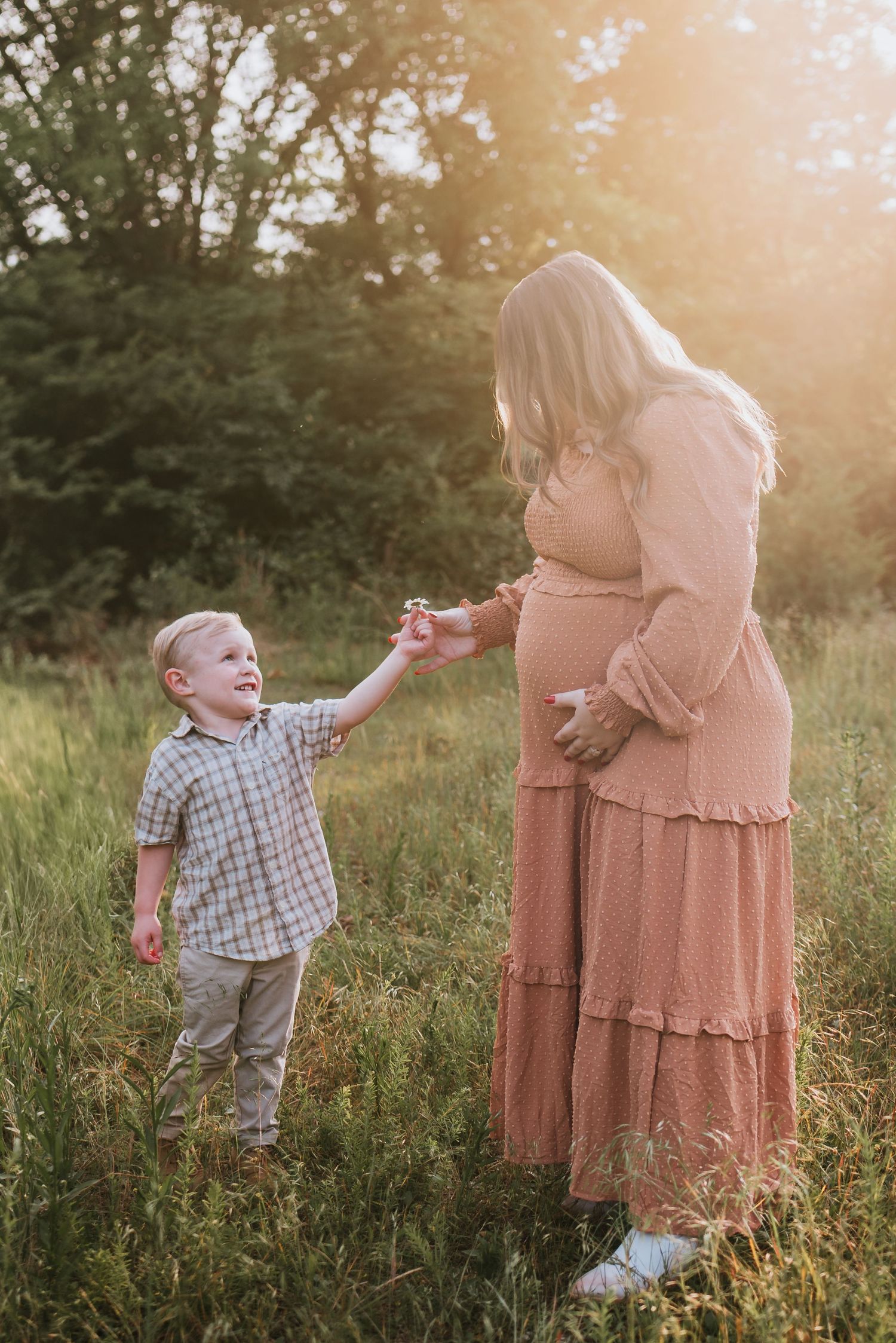 Toddler handing mom flower in a field in Chattanooga, TN – family maternity session, soft summer light