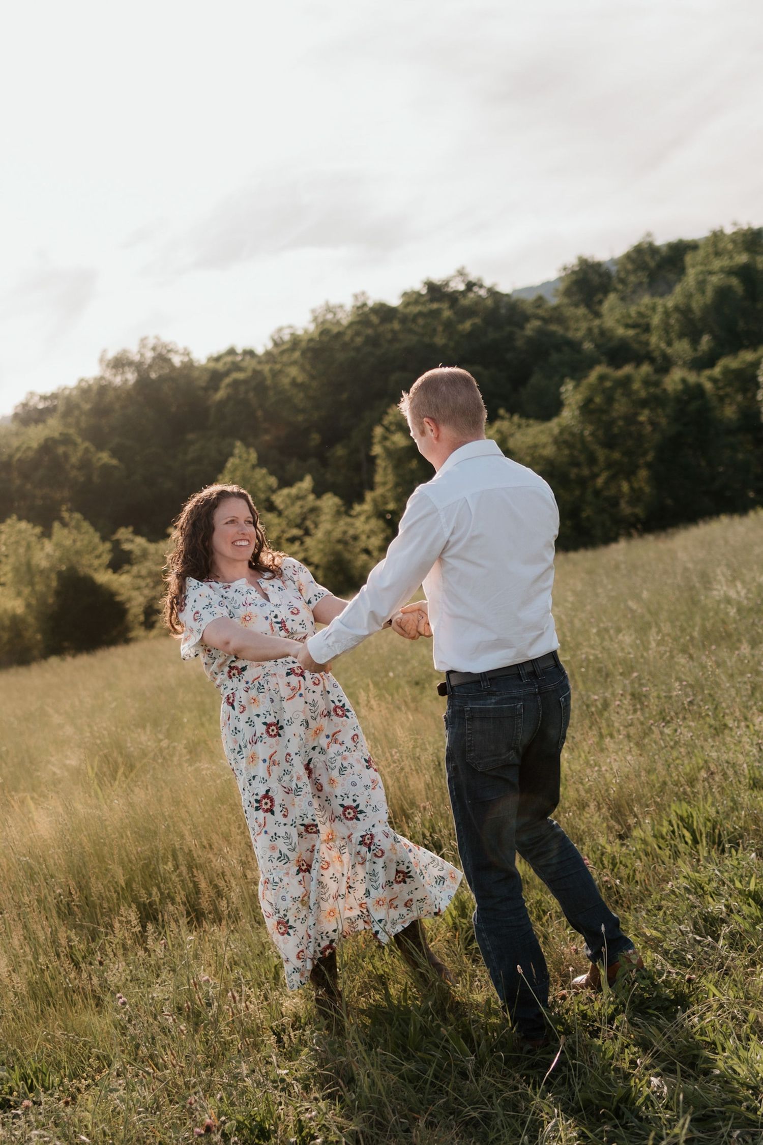 Couple spinning in an open field near raccoon mountain chattanooga TN, warm golden light