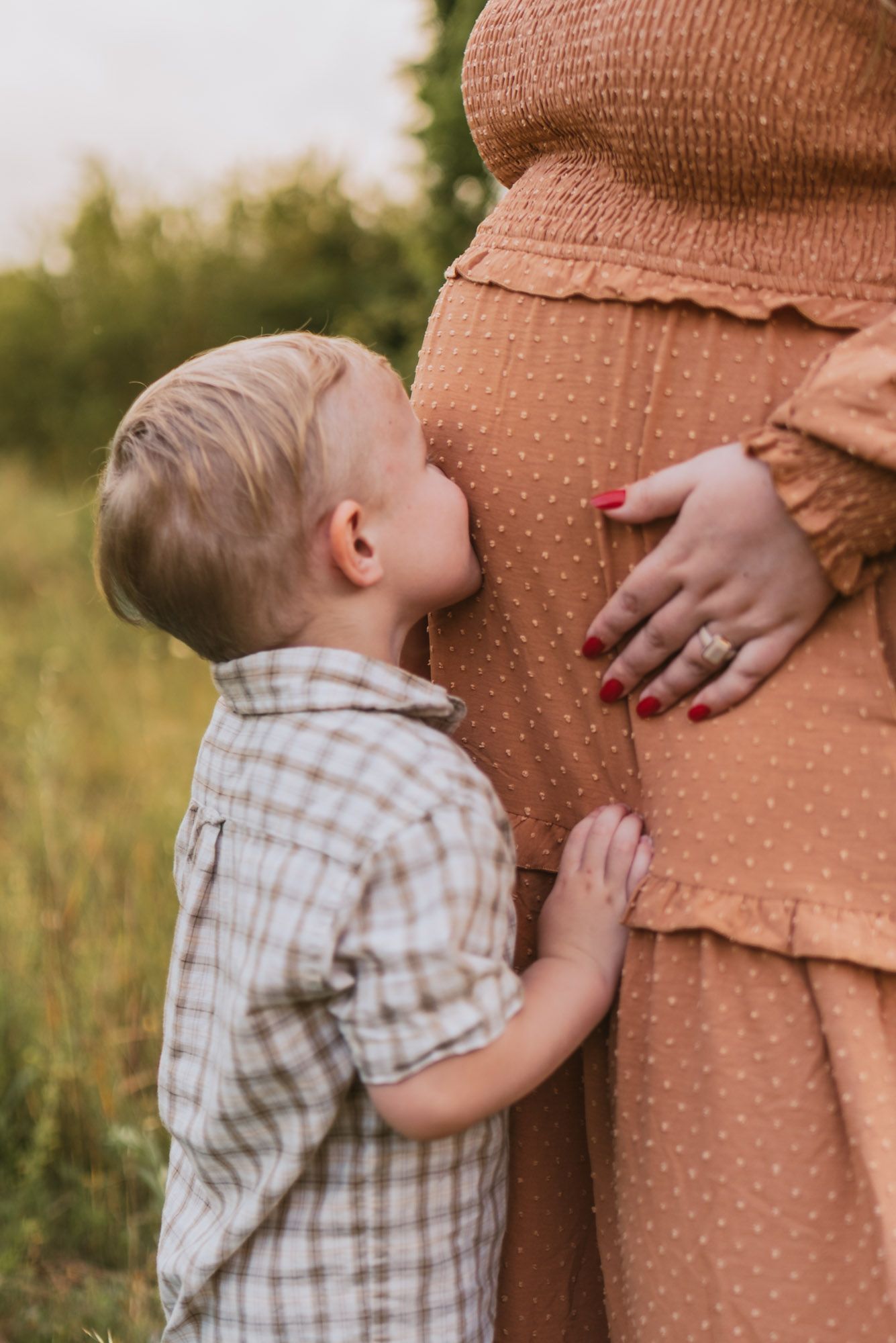 Close up of toddler kissing expecting moms belly in field during family maternity session at raccoon mountain, Chattanooga TN, golden hour