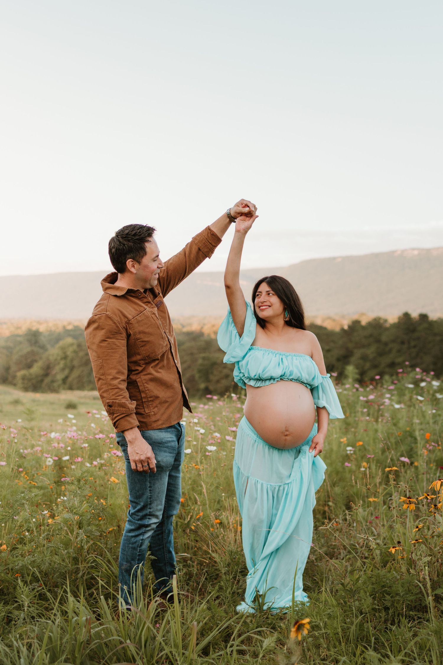 Couple dancing in a wildflower field at Fox Mountain Farms, Chattanooga, TN – maternity session, soft summer light