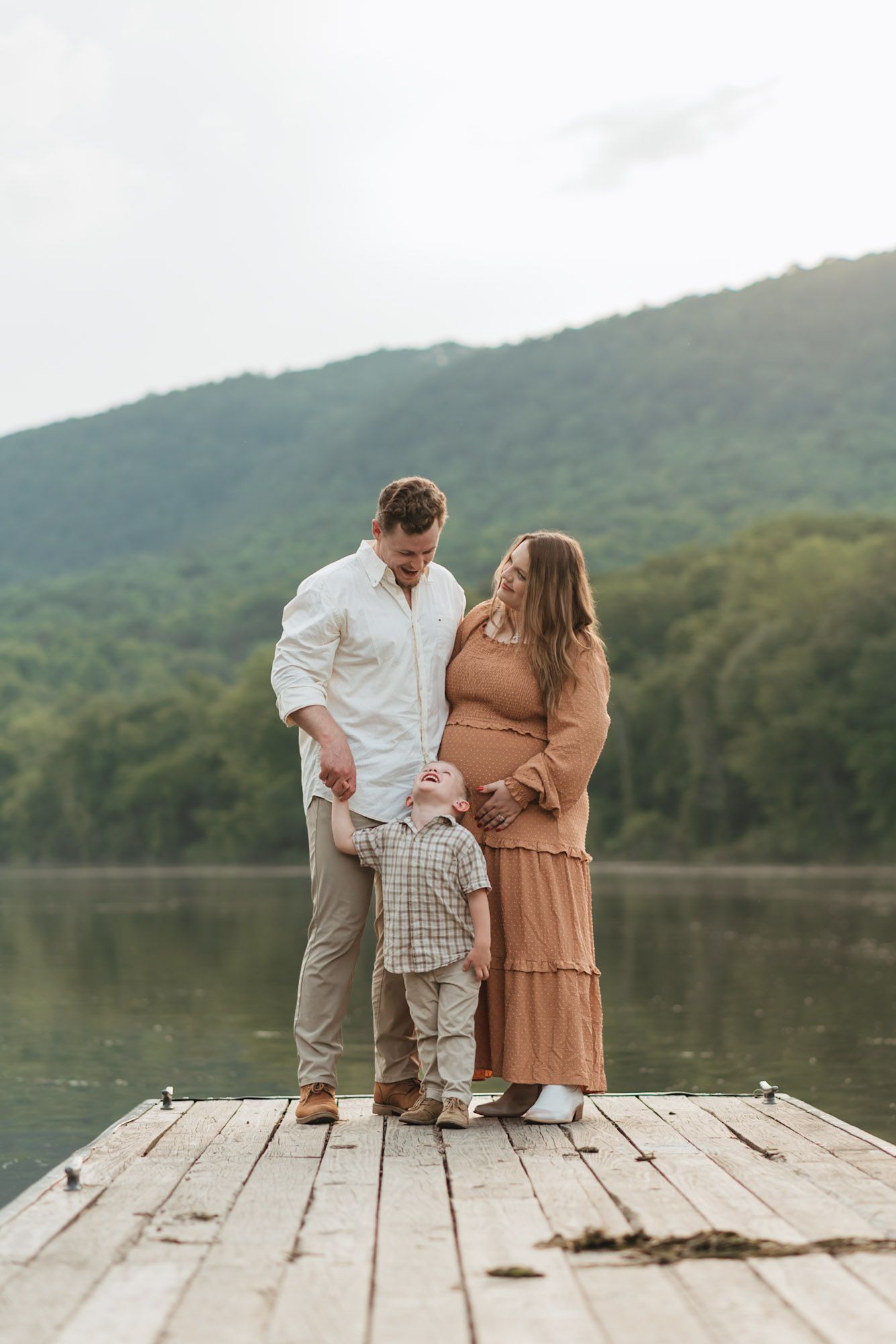 Family standing on dock looking at each other during family maternity session at raccoon mountain, Chattanooga TN, water and mountains