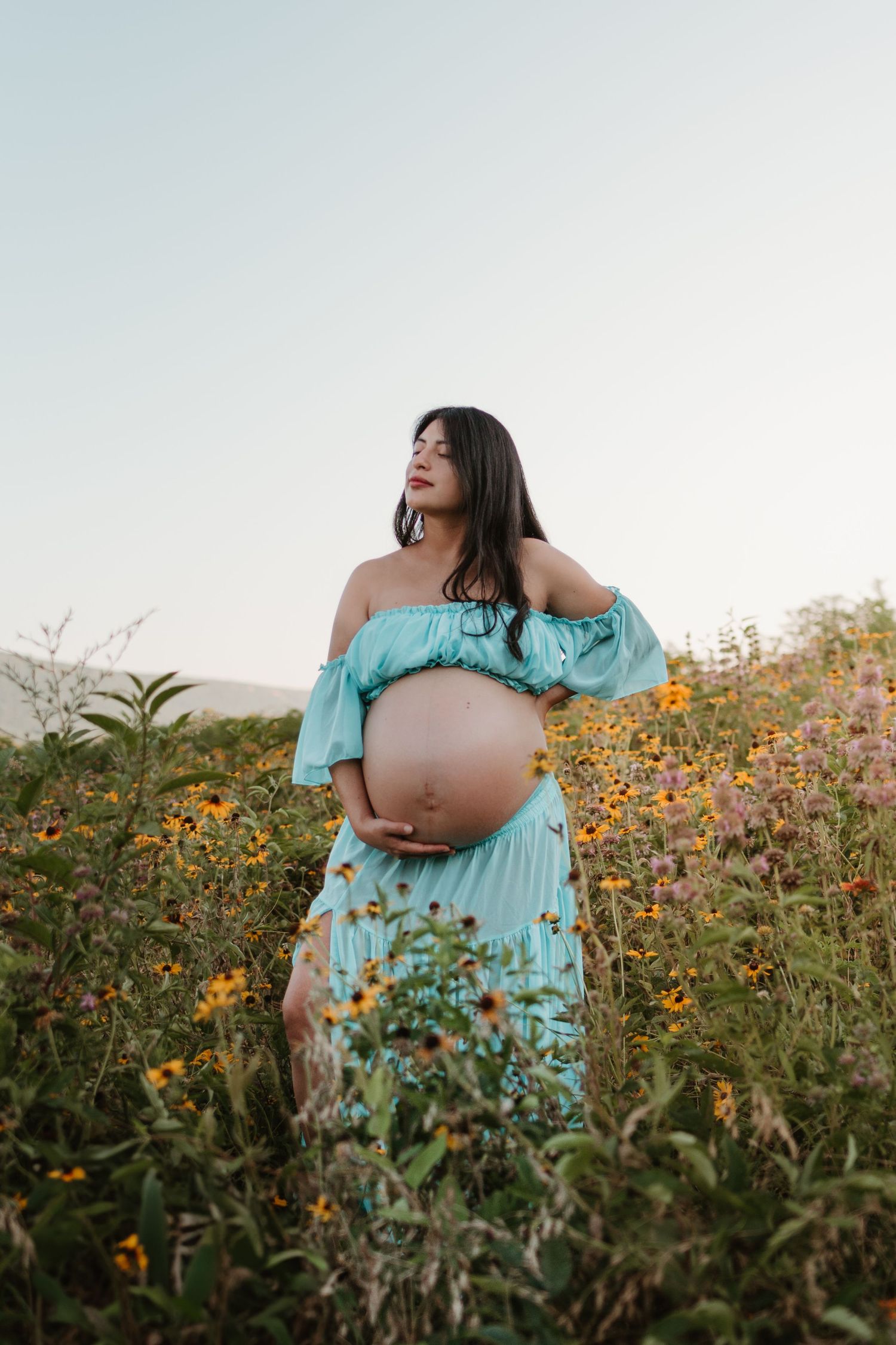 Itzayana eyes closed in a wildflower field at Fox Mountain Farms, Chattanooga, TN – maternity session, soft summer light