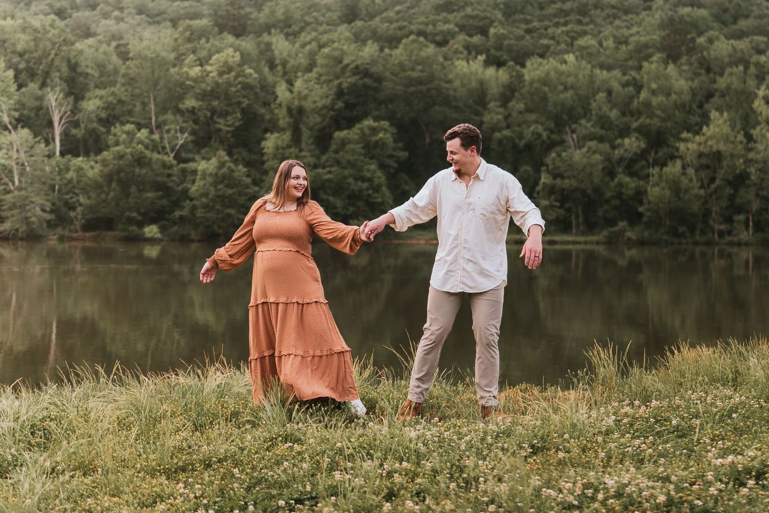 Couple walking in a field in Chattanooga, TN – family maternity session, soft summer light, water