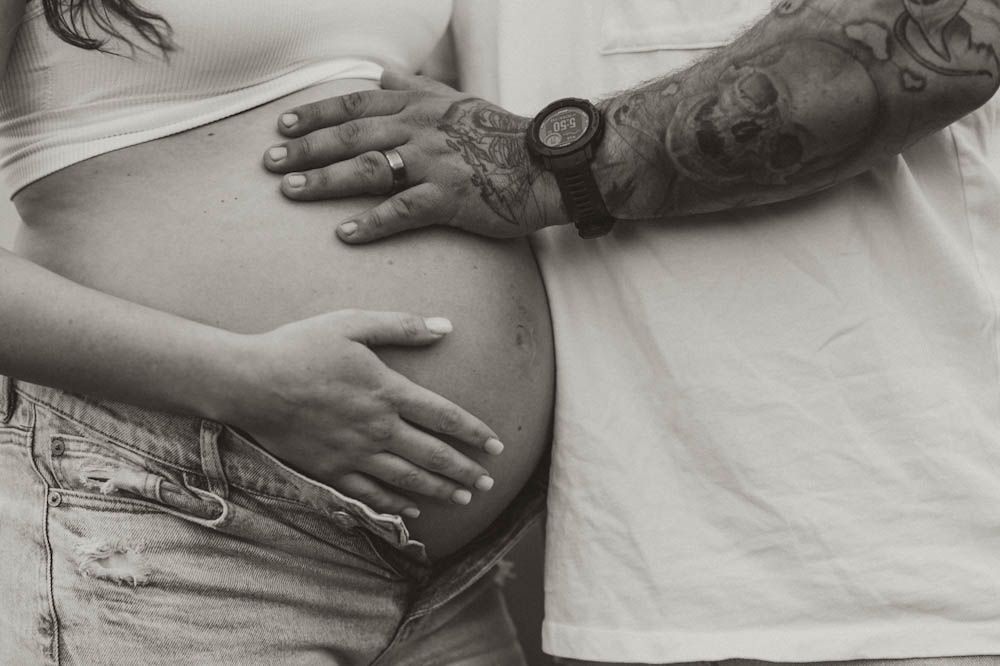 Close up black and white photo of expecting couple with hands on moms baby bump, maternity session on raccoon mountain, Chattanooga, TN