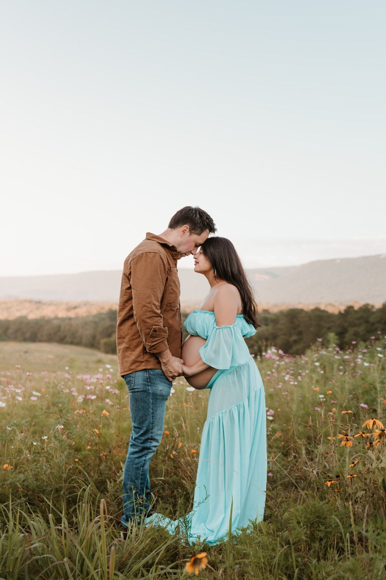 Expecting couple standing in a wildflower field during golden hour maternity session at Fox Mountain Farm in Rising Fawn, Georgia