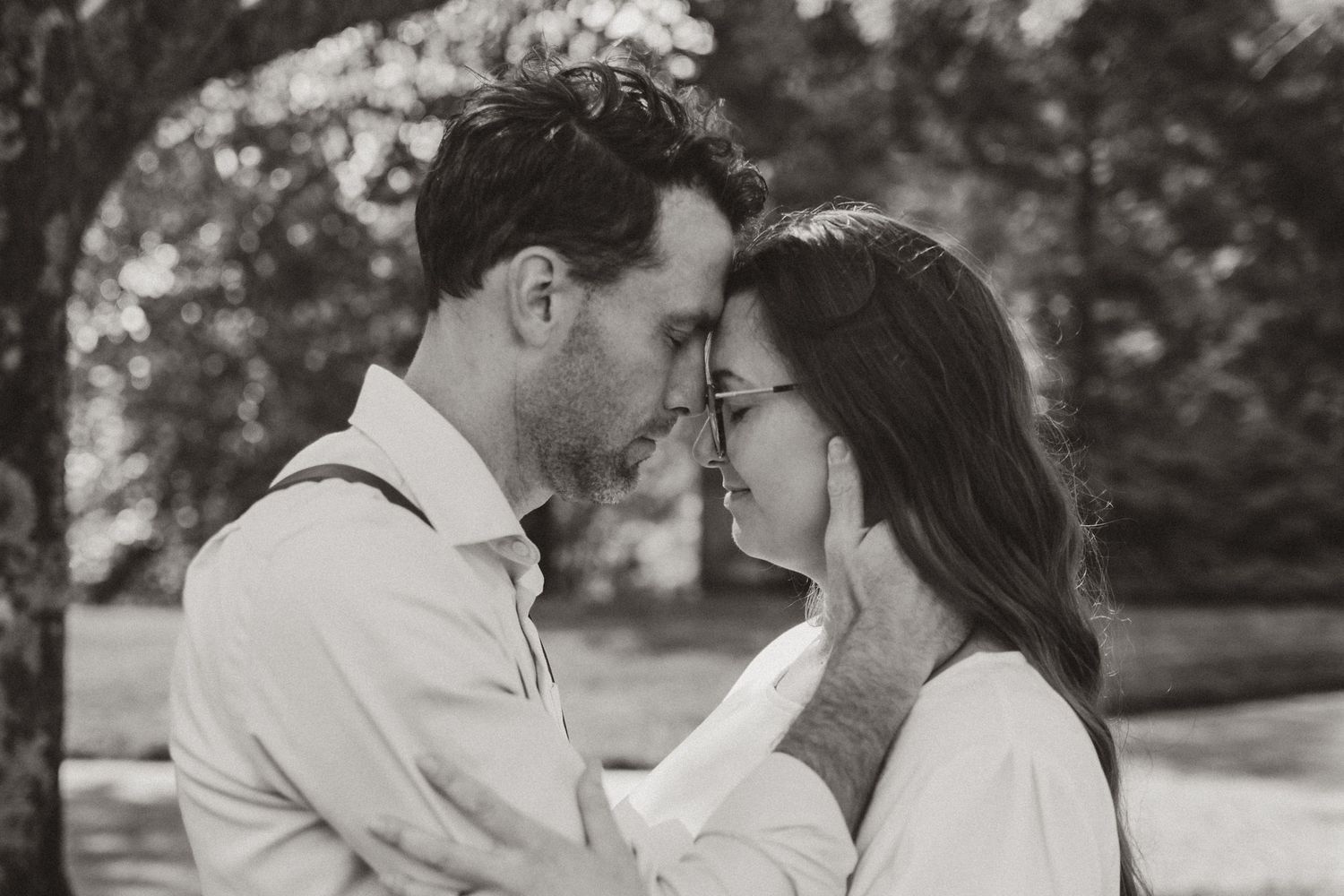 Black and white portrait of couple forehead to forehead eyes closed, outdoor morning session on lookout mountain Georgia, morning light thro