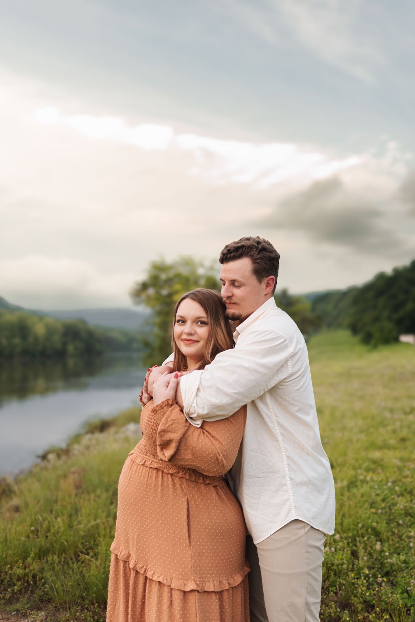 Expecting couple standing close with water and mountains in background at raccoon mountain, chattanooga TN