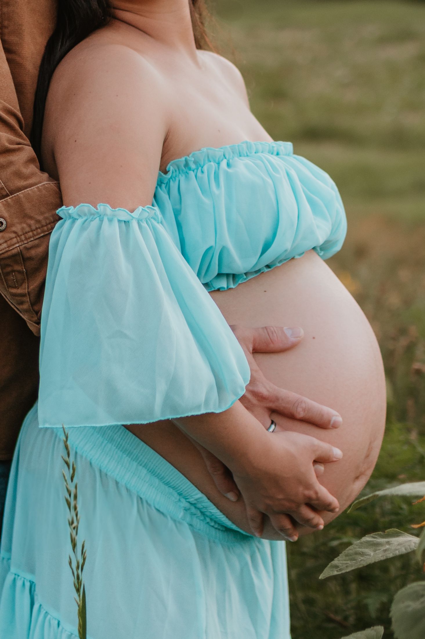 Close up of couple holding belly in a wildflower field at Fox Mountain Farms, Chattanooga, TN – maternity session, soft summer light