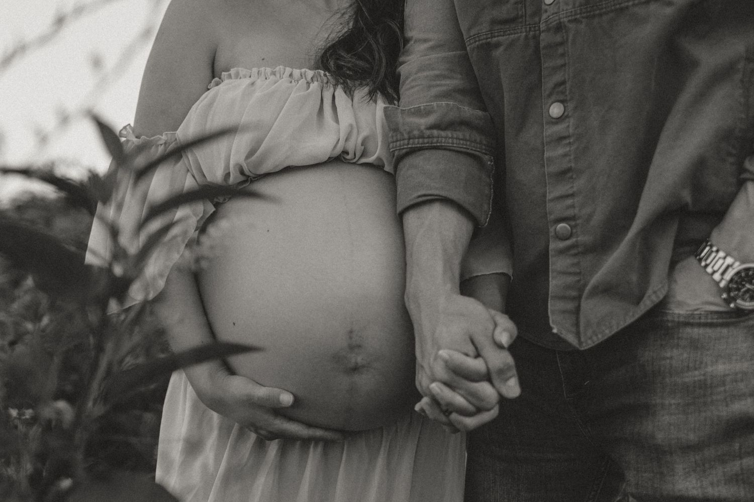 B&W couple holding hands in a wildflower field at Fox Mountain Farms, Chattanooga, TN – maternity session, soft summer l