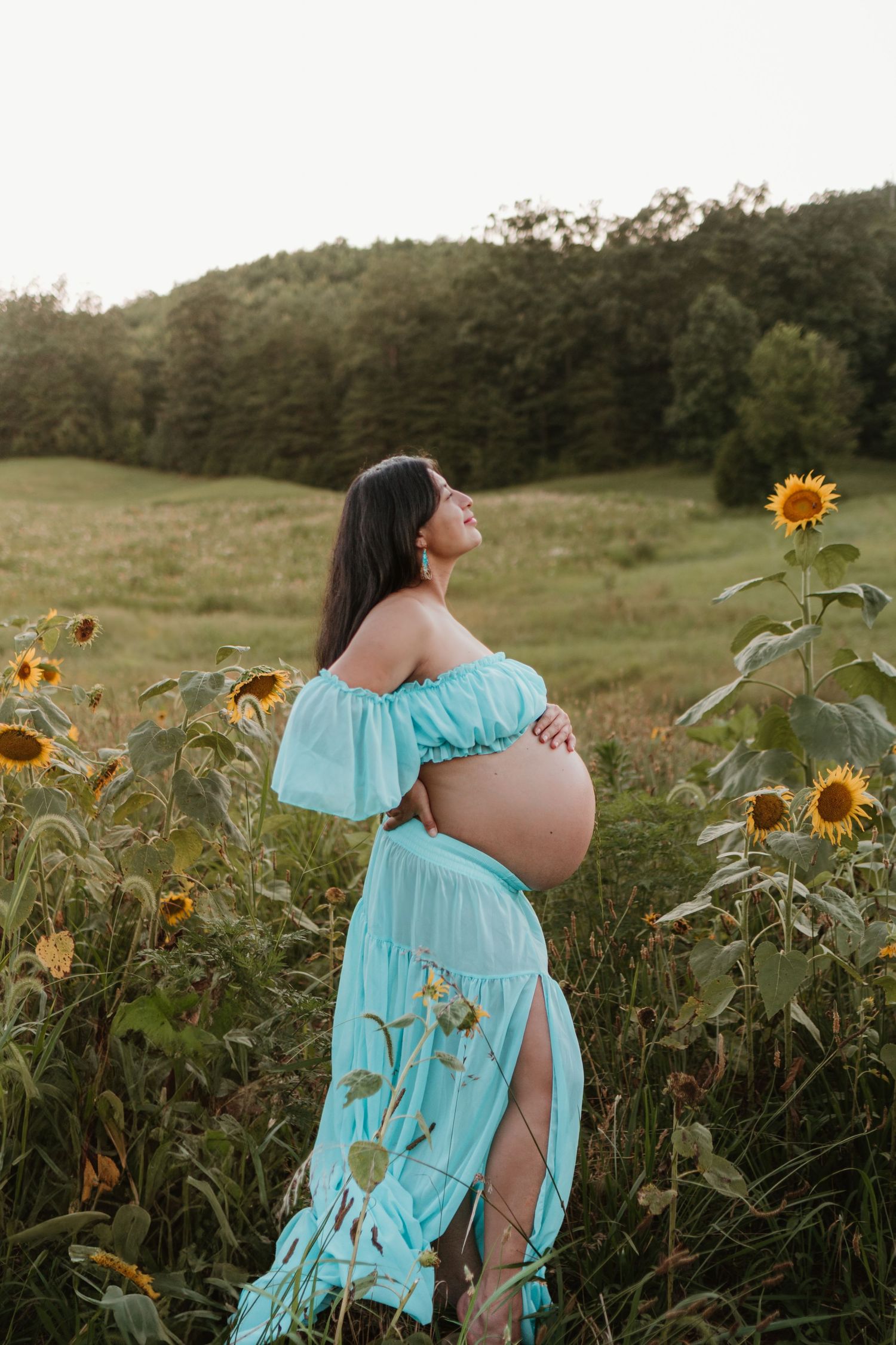 Itzayana looking towards sky in sunflower field at Fox Mountain Farms, Chattanooga, TN – maternity session, soft summer light