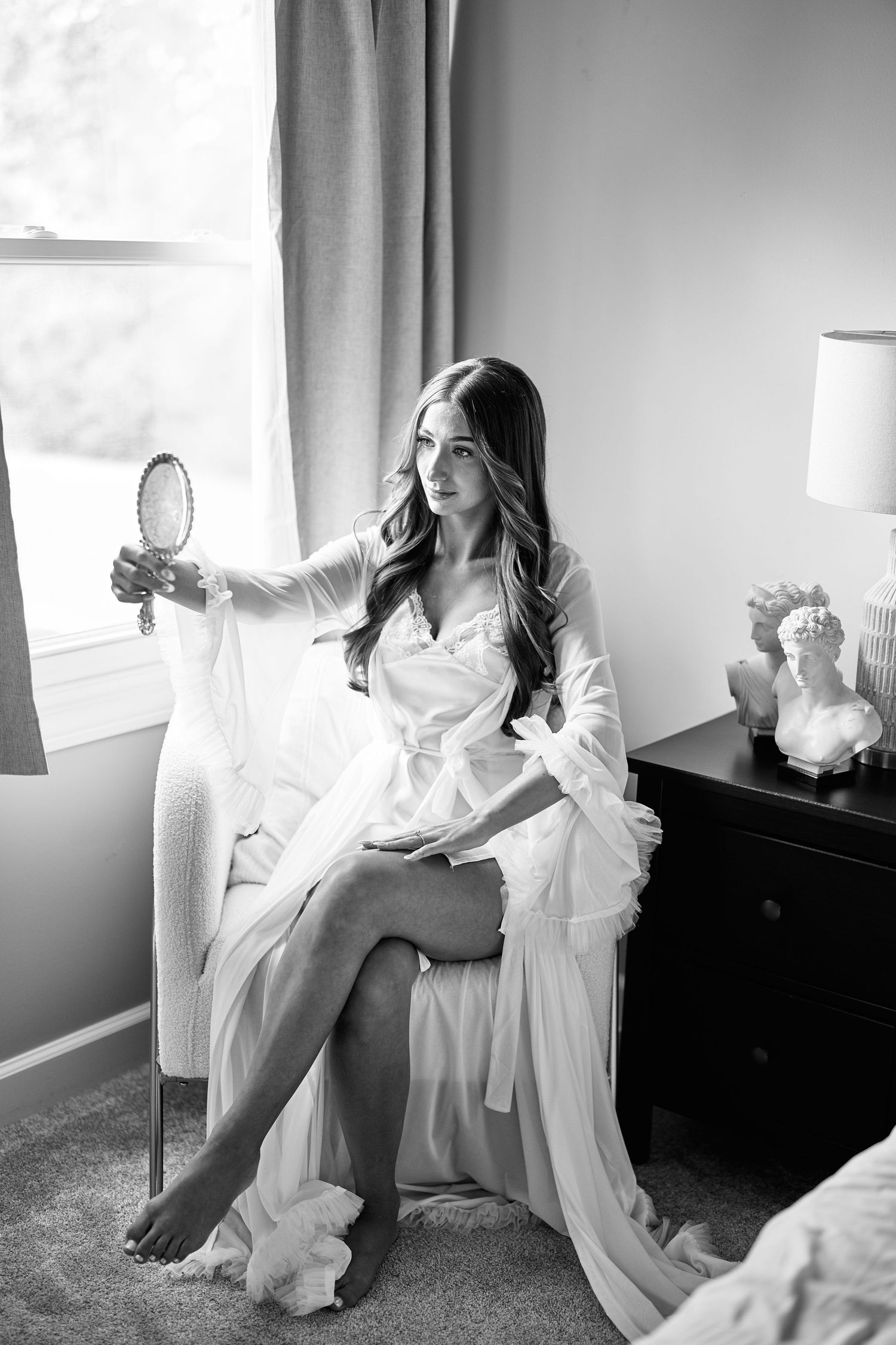 Black and white boudoir photos showing a woman in white lingerie lounging elegantly in a sunlit room.