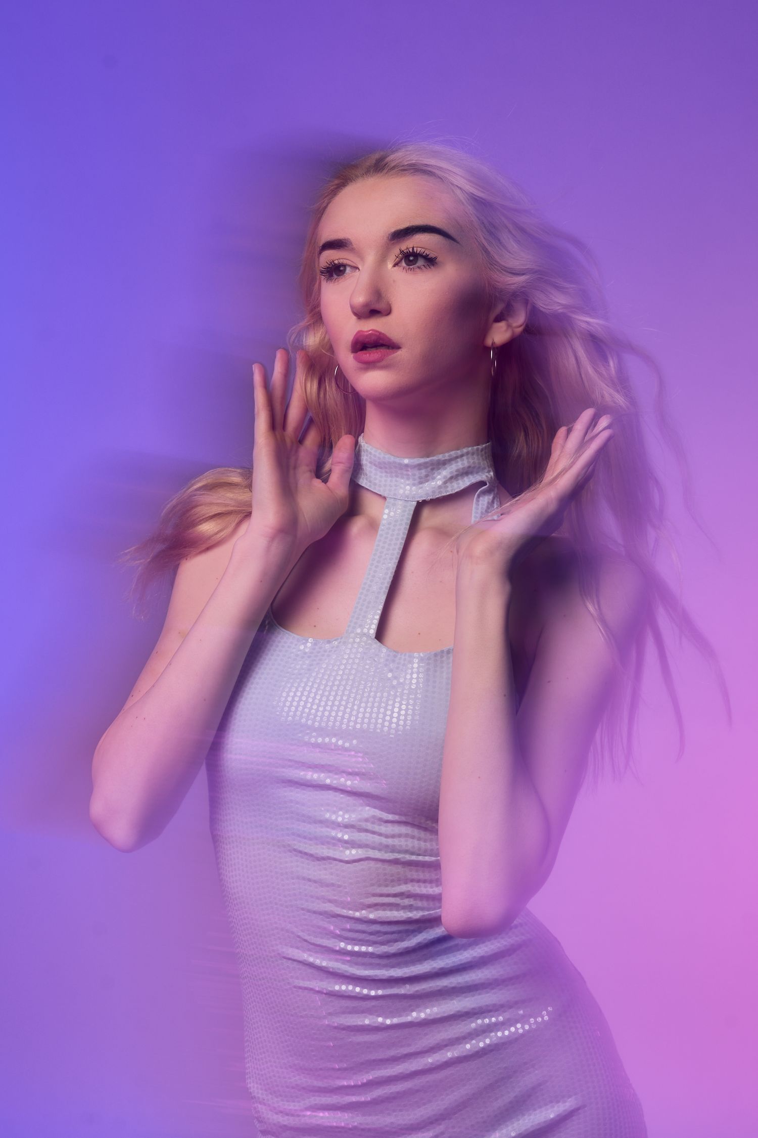 Fashion portrait with purple lighting and dreamy atmospheric effects.