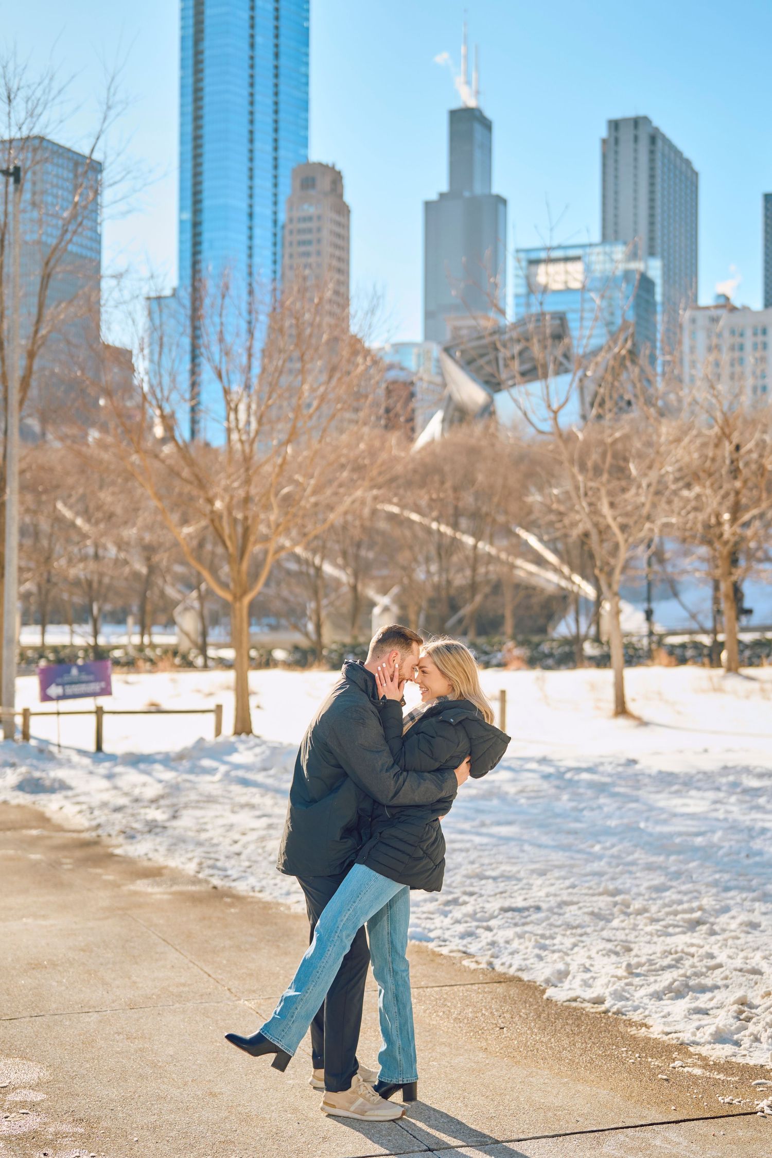 A winter cityscape in Chicago with snow-covered ground and tall skyscrapers in the background.