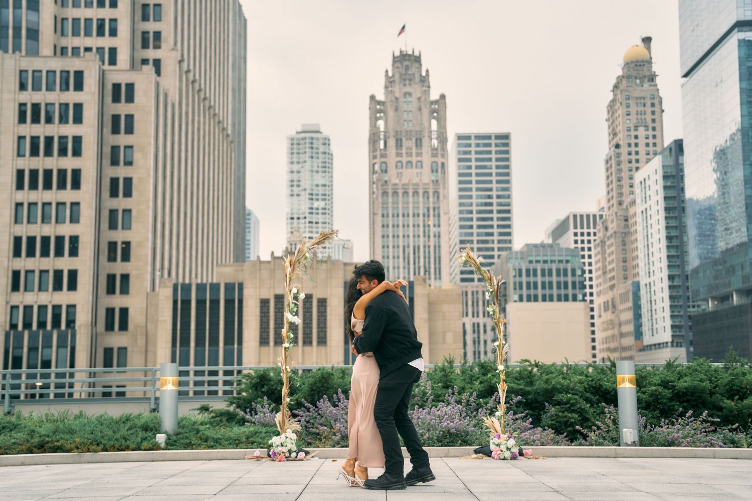 A couple embraces during their wedding photo session with Chicago's iconic skyline in the background.
