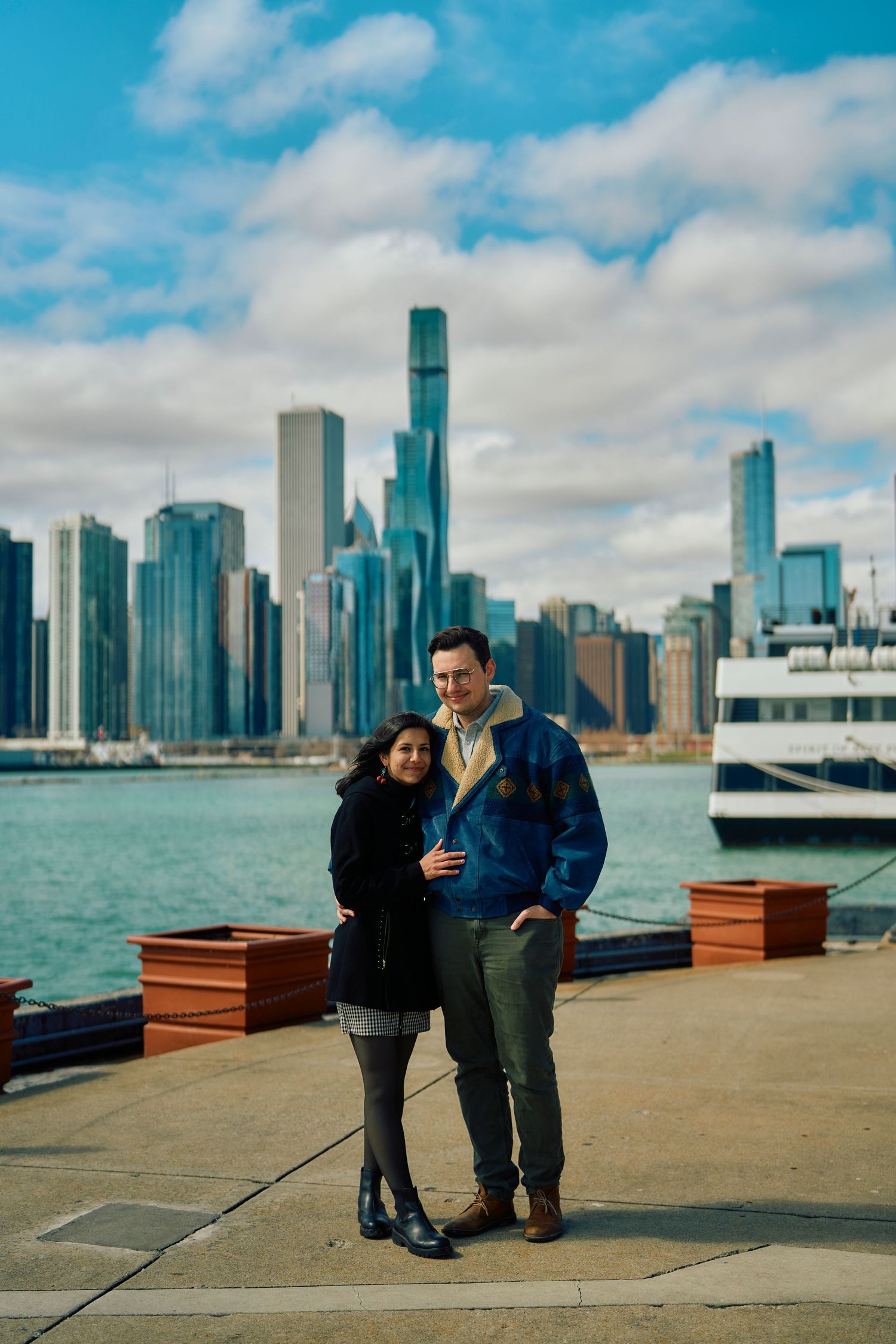 A couple enjoys a romantic moment on the waterfront with Chicago's iconic skyline and Lake Michigan in the background.