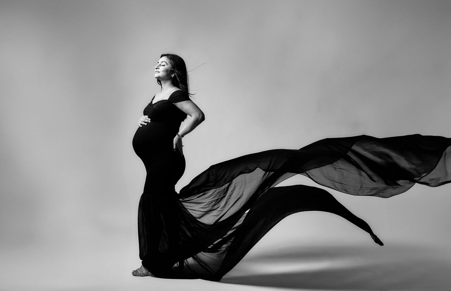 Artistic black and white photo sequence showing flowing fabric movement in six dramatic poses.