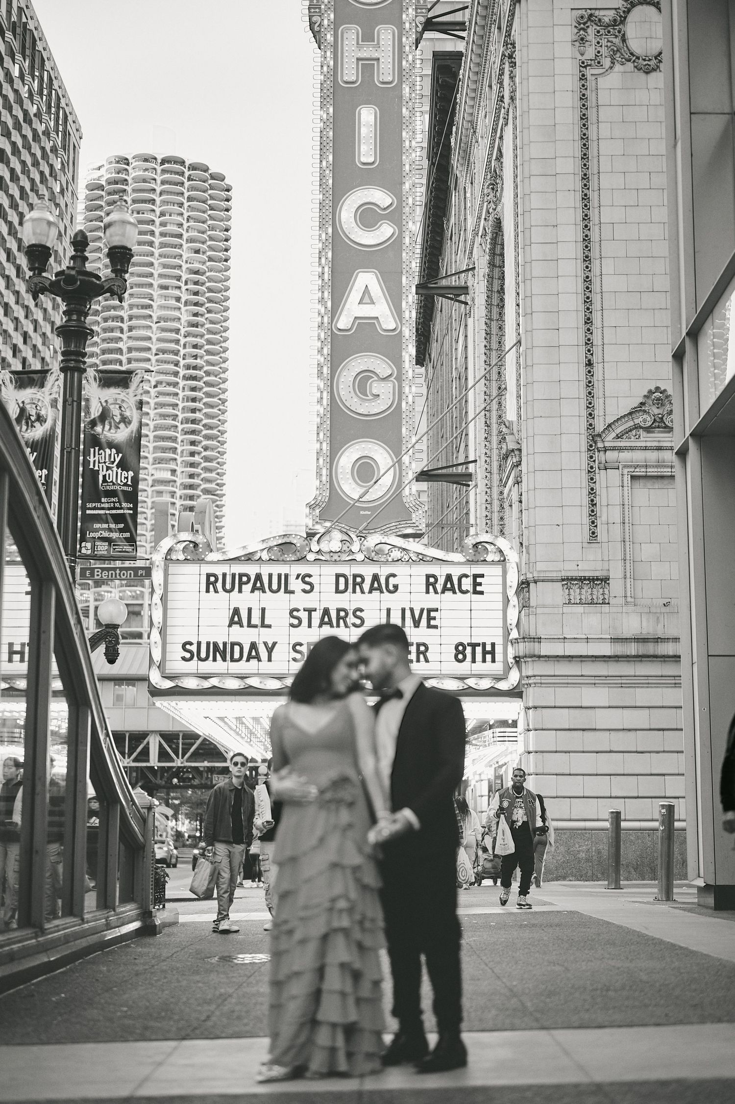 Vintage black and white photo of a couple posing outside Chicago Theatre with RuPaul's Drag Race marquee visible.
