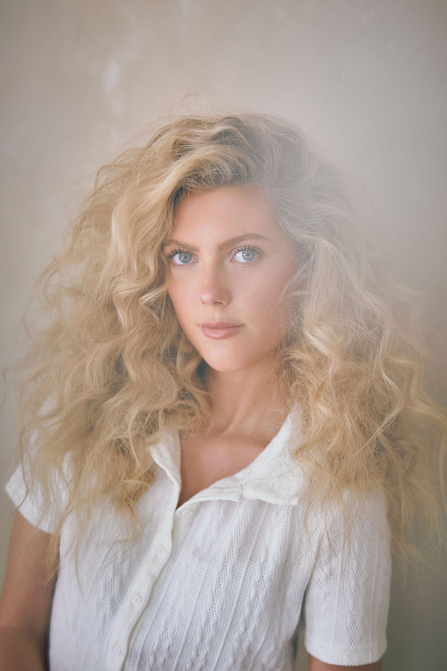 Ethereal portrait series showing a figure with voluminous blonde hair and white clothing against a soft neutral background.