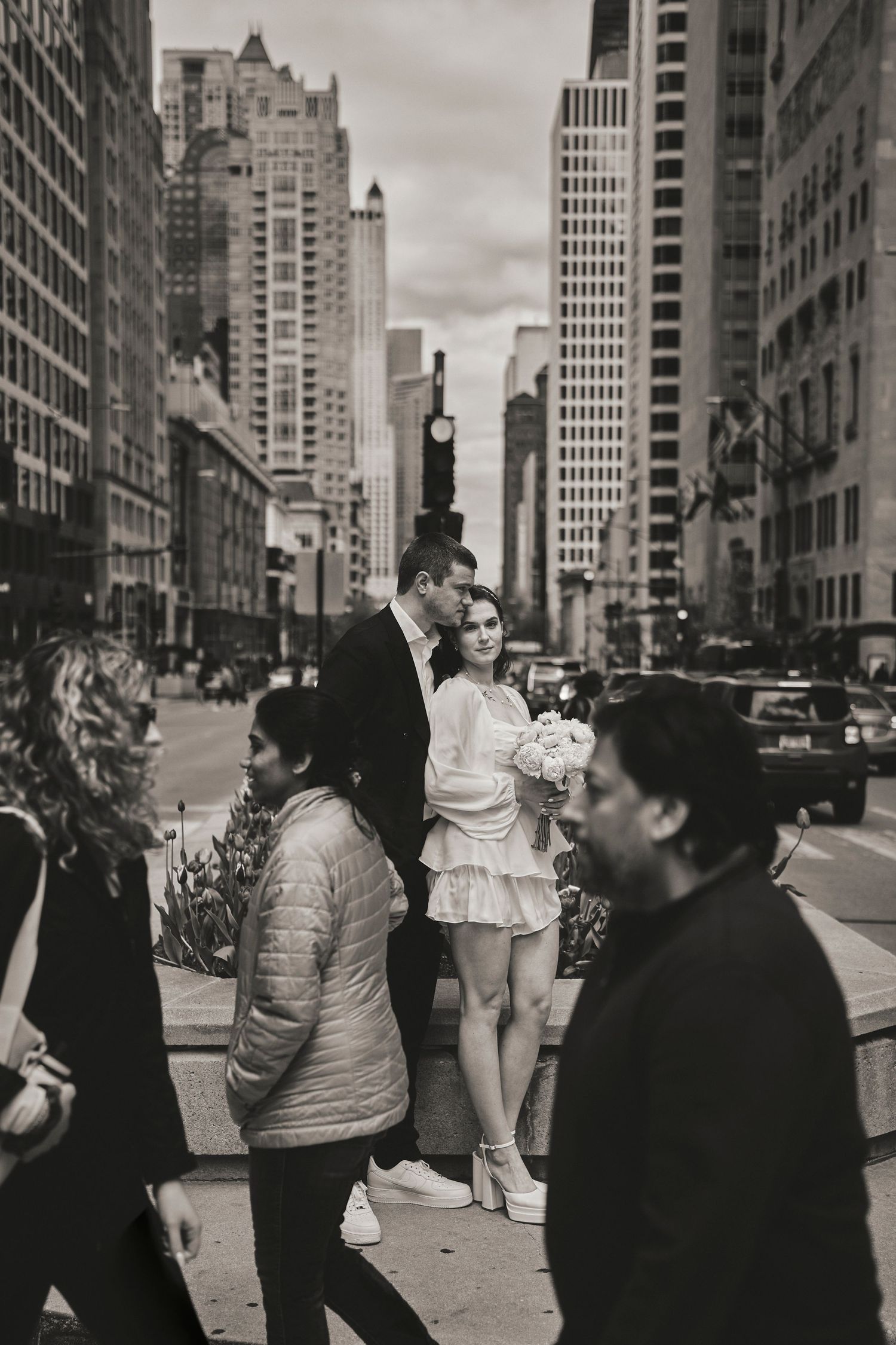 Urban street scene in NYC with city skyscrapers and pedestrians walking on a busy sidewalk.