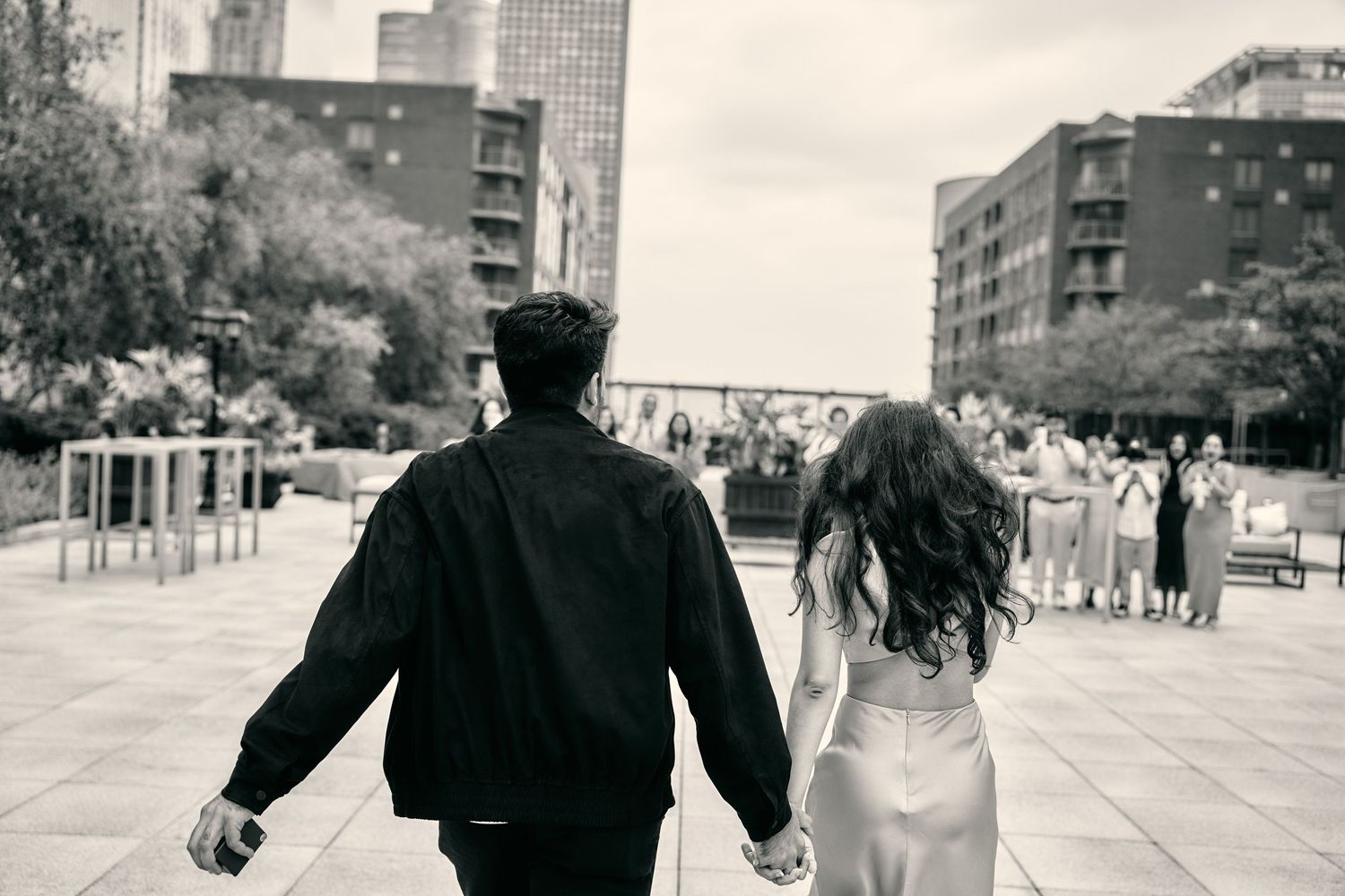 A black and white photo montage shows people walking through city streets with tall buildings in the background.