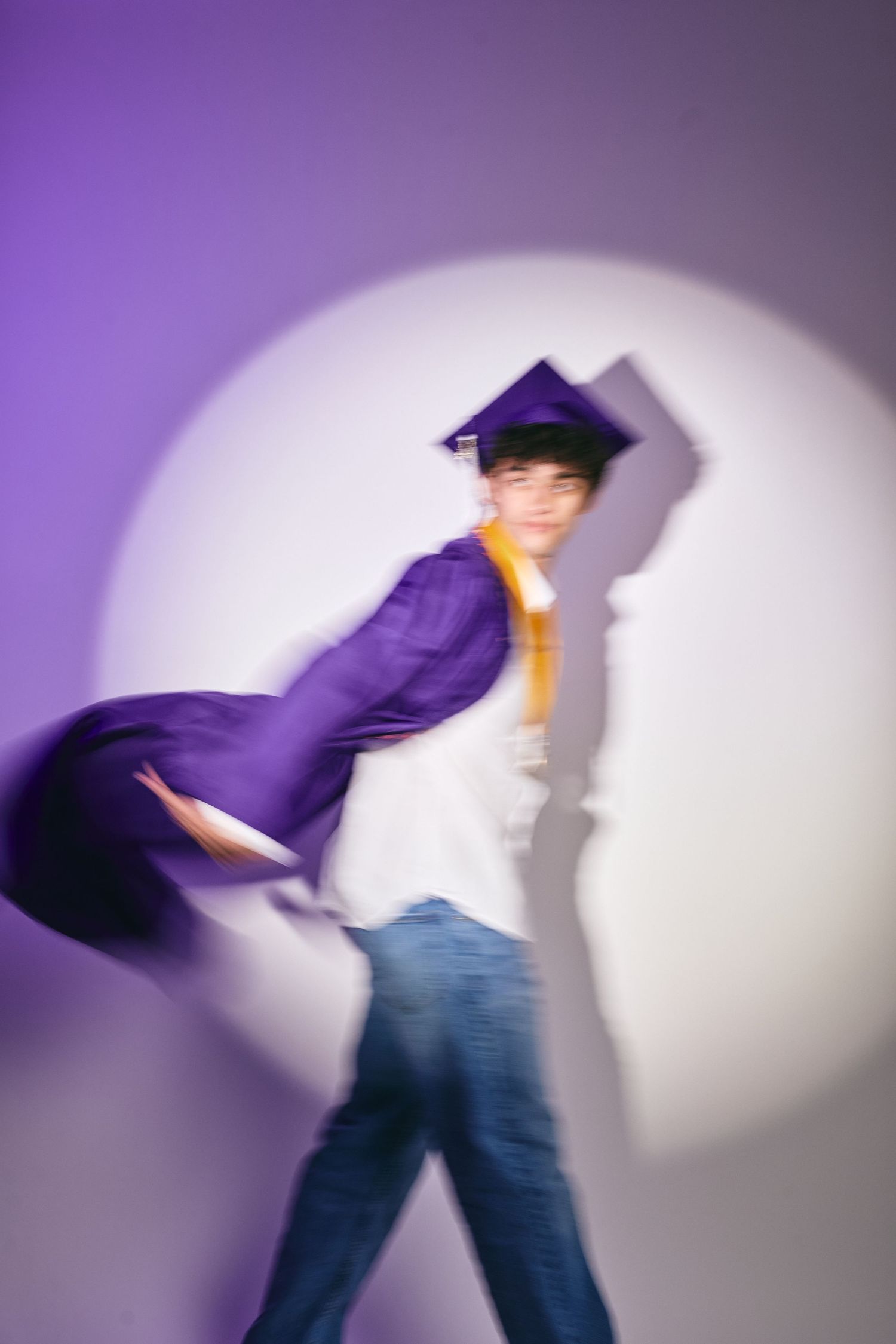 Motion blur sequence shows figure in jeans and purple top dancing against white backdrop in dynamic poses.