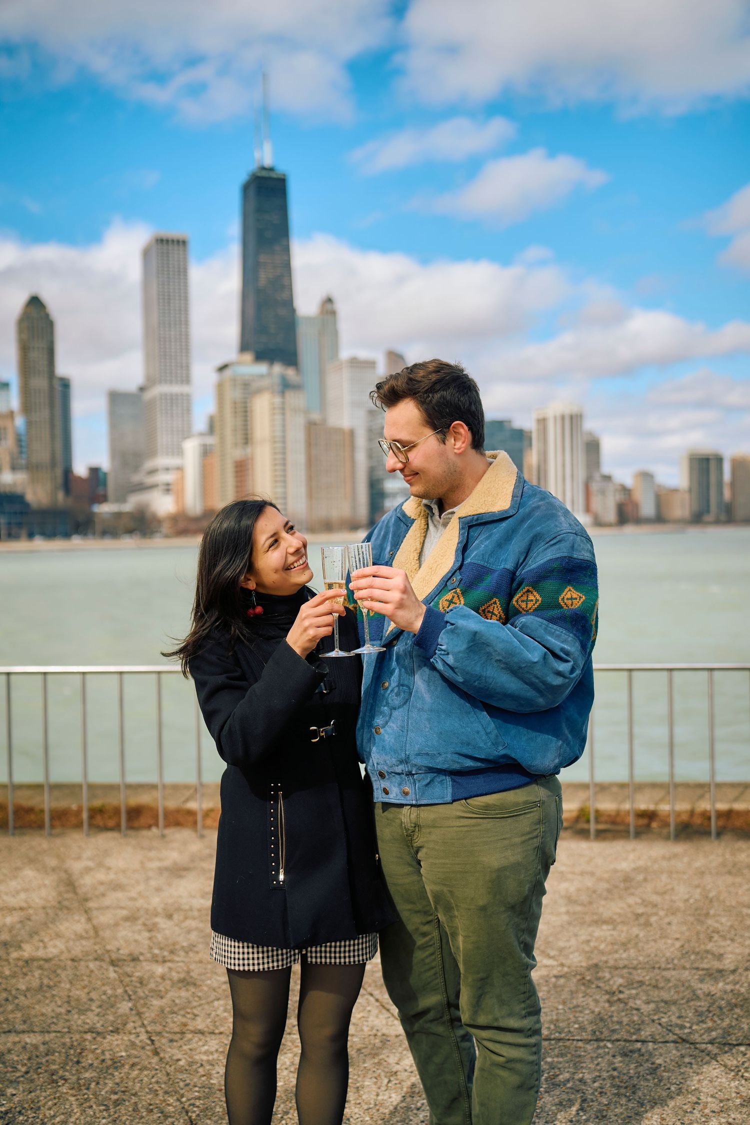 Couple sharing drinks with Chicago skyline and Lake Michigan views at Navy Pier on a sunny afternoon.