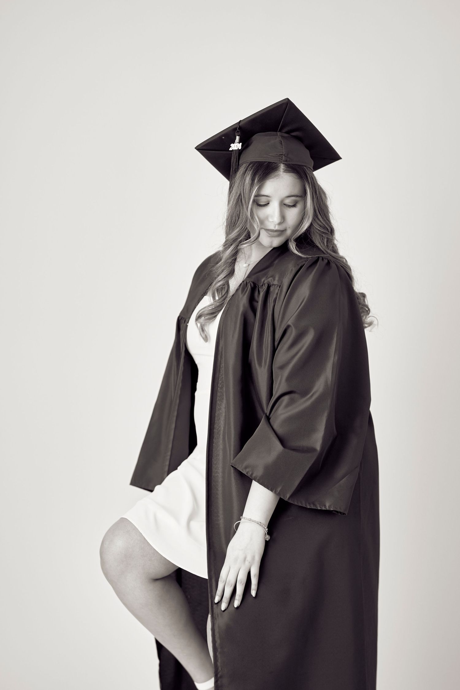 Black and white graduation portrait showing academic regalia and cap.
