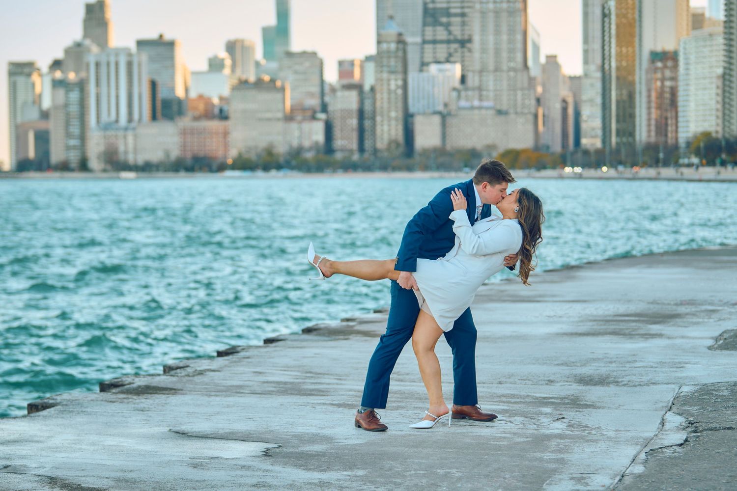 Romantic couple dancing on Chicago's lakefront with the city skyline and Lake Michigan in the background at sunset.