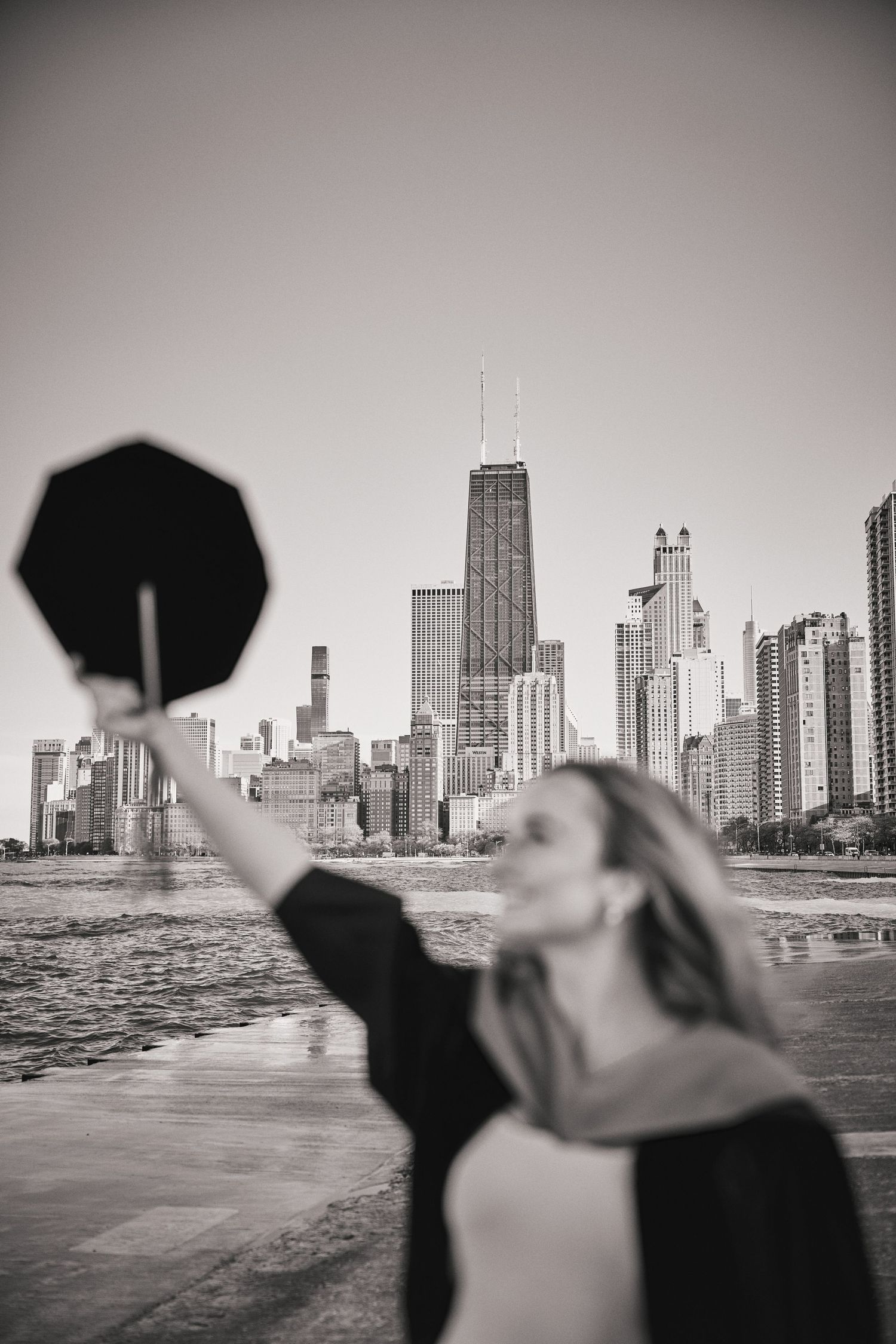 Black and white series of photos showing someone holding an umbrella against a dramatic Chicago skyline backdrop.