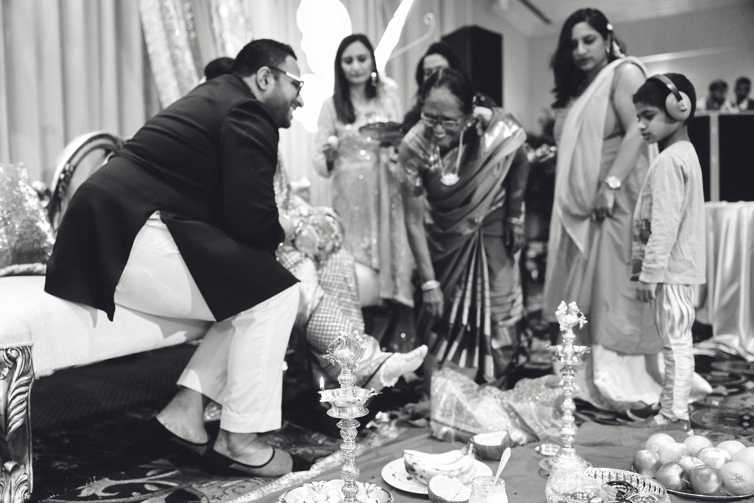 A person performs wedding preparations and rituals during a black and white traditional Indian ceremony.