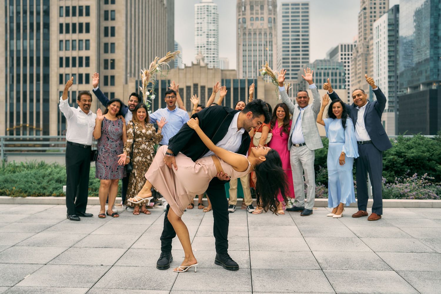 Couple dancing and dipping in front of a cheering crowd with Chicago city skyline in background.
