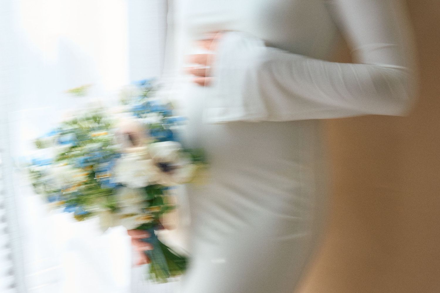 A close-up shot of a white wedding dress with delicate lace details and floral embellishments.