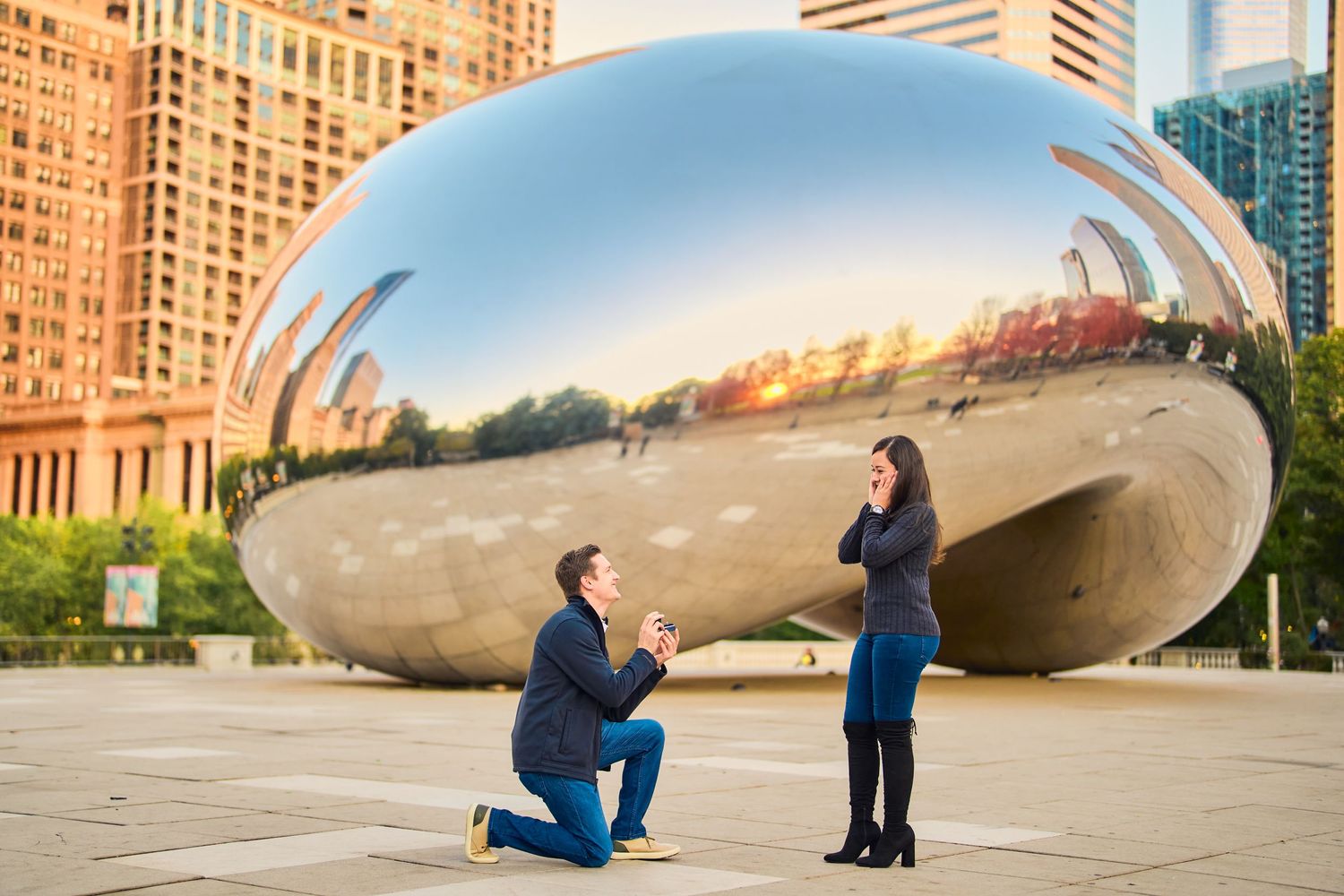 A proposal in front of Cloud Gate, the reflective bean-shaped sculpture in Chicago's Millennium Park at sunset.