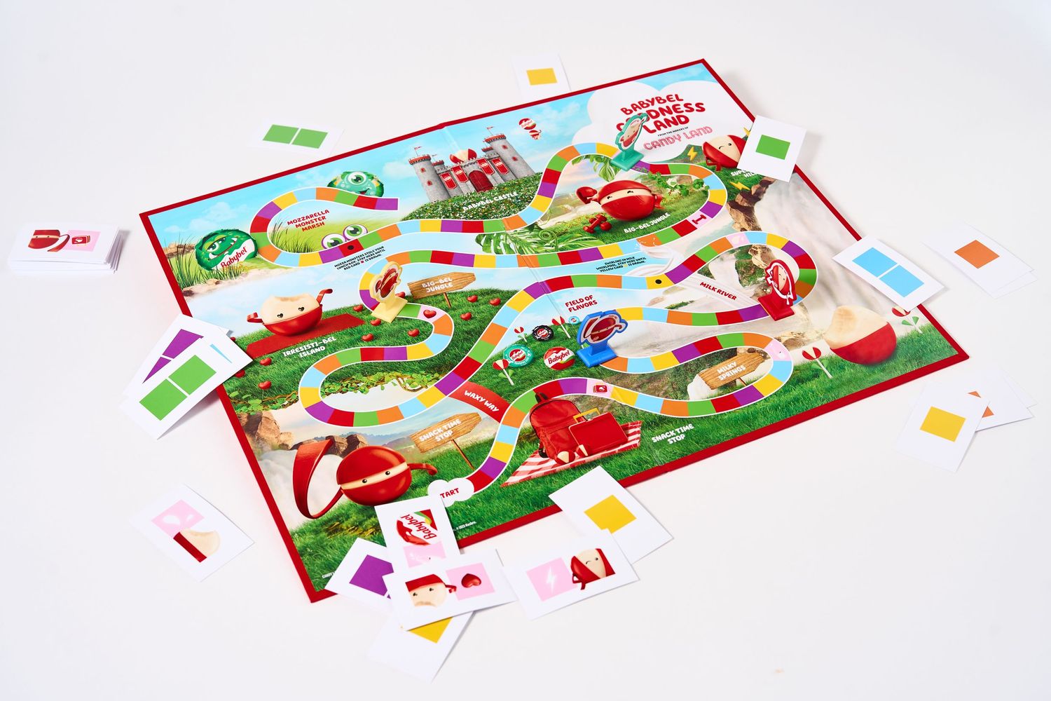 Opened board game showing colorful path layout with scattered game pieces and cards.