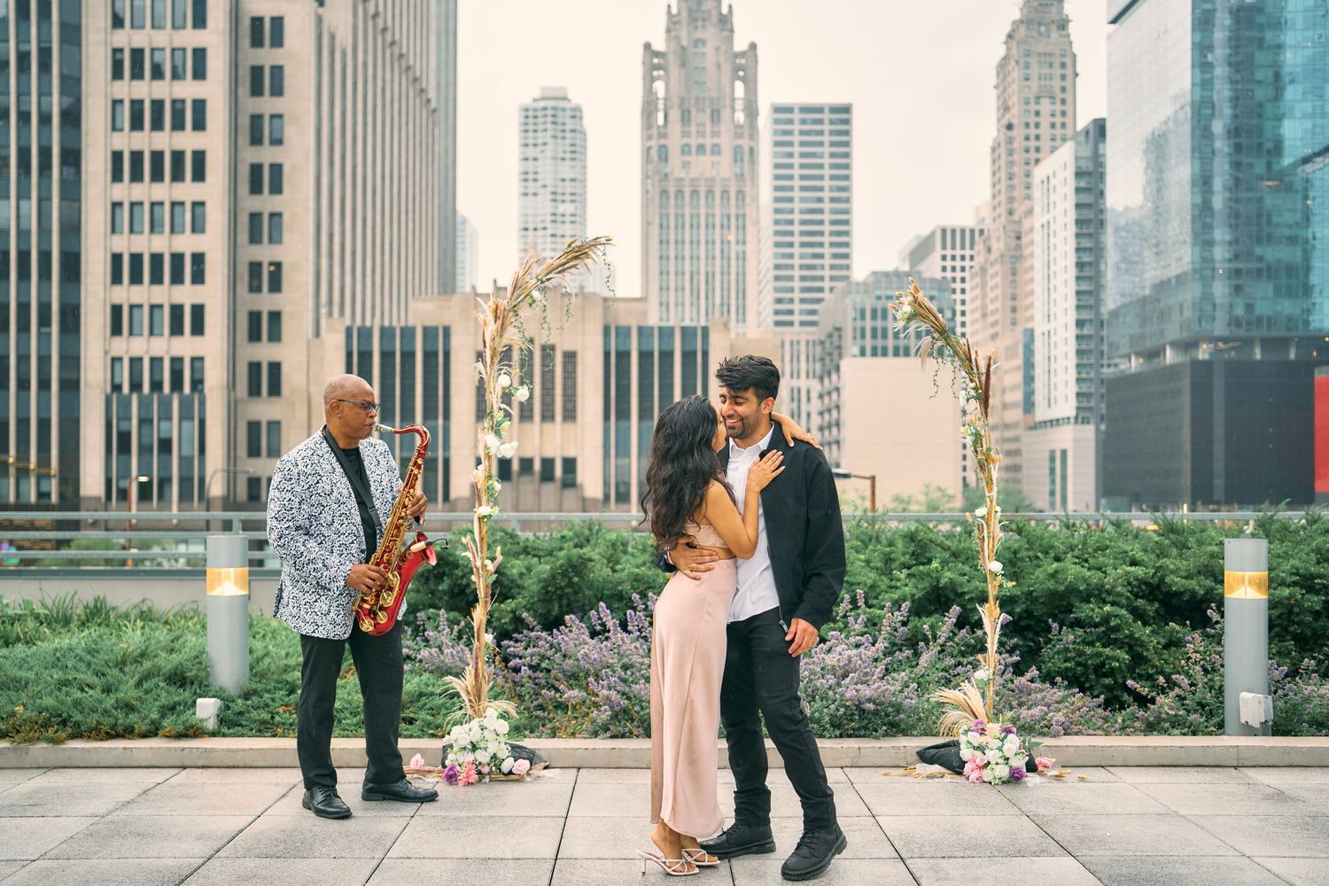 A rooftop wedding ceremony in New York City with decorative floral arch and stunning urban skyline backdrop.