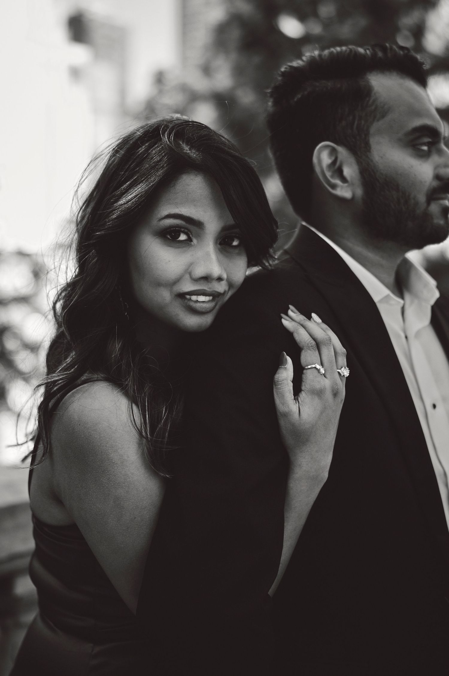 Elegant black and white portrait of a couple in formal attire posing together in a romantic style.