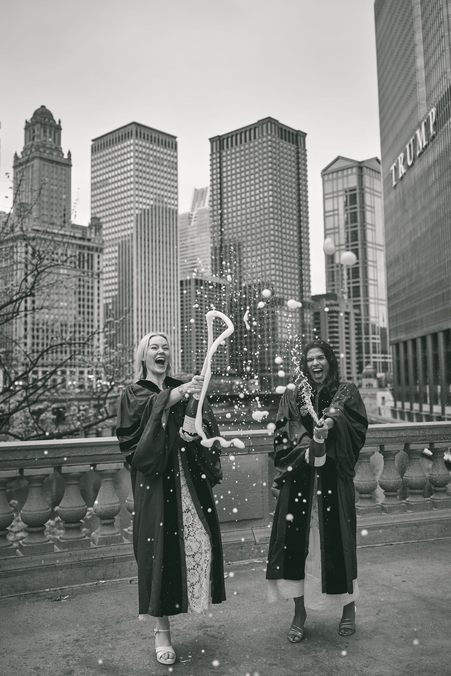 Three people in winter coats enjoy a snowy day in front of the Chicago skyline.