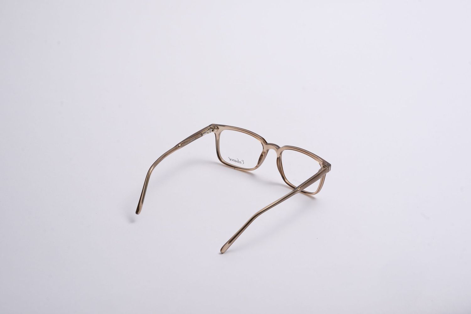 Brown rectangular eyeglass frames viewed from side angle on white background.