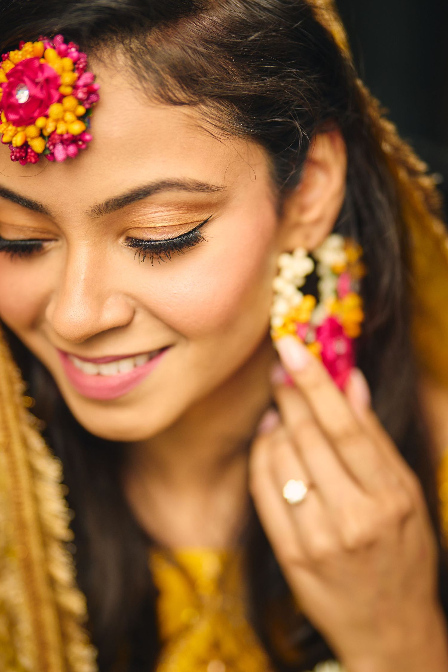 A close-up series showing traditional Indian bridal makeup and jewelry with pink flowers and gold accents.