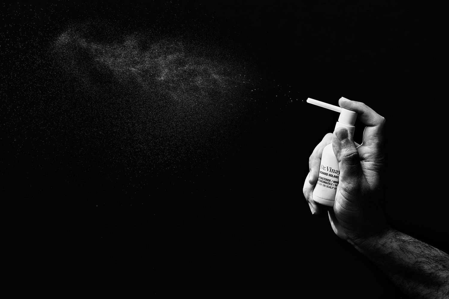 Black and white artistic photograph of a lit cigarette with smoke against dark background.