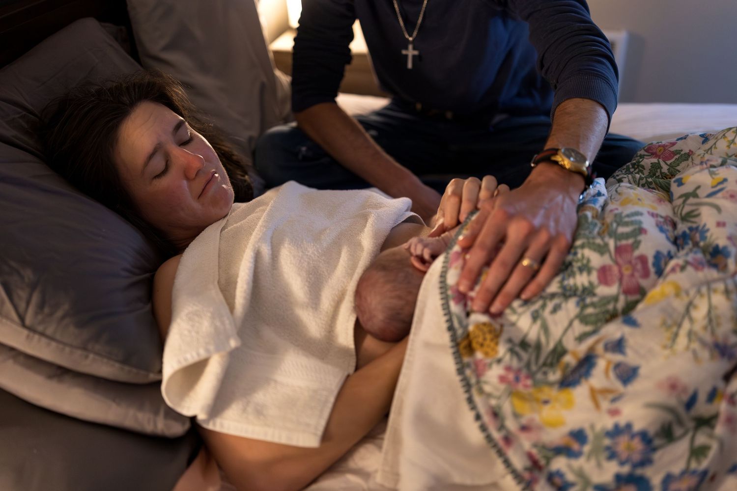 A new mother cries as she holds her newborn on her belly moments after birth