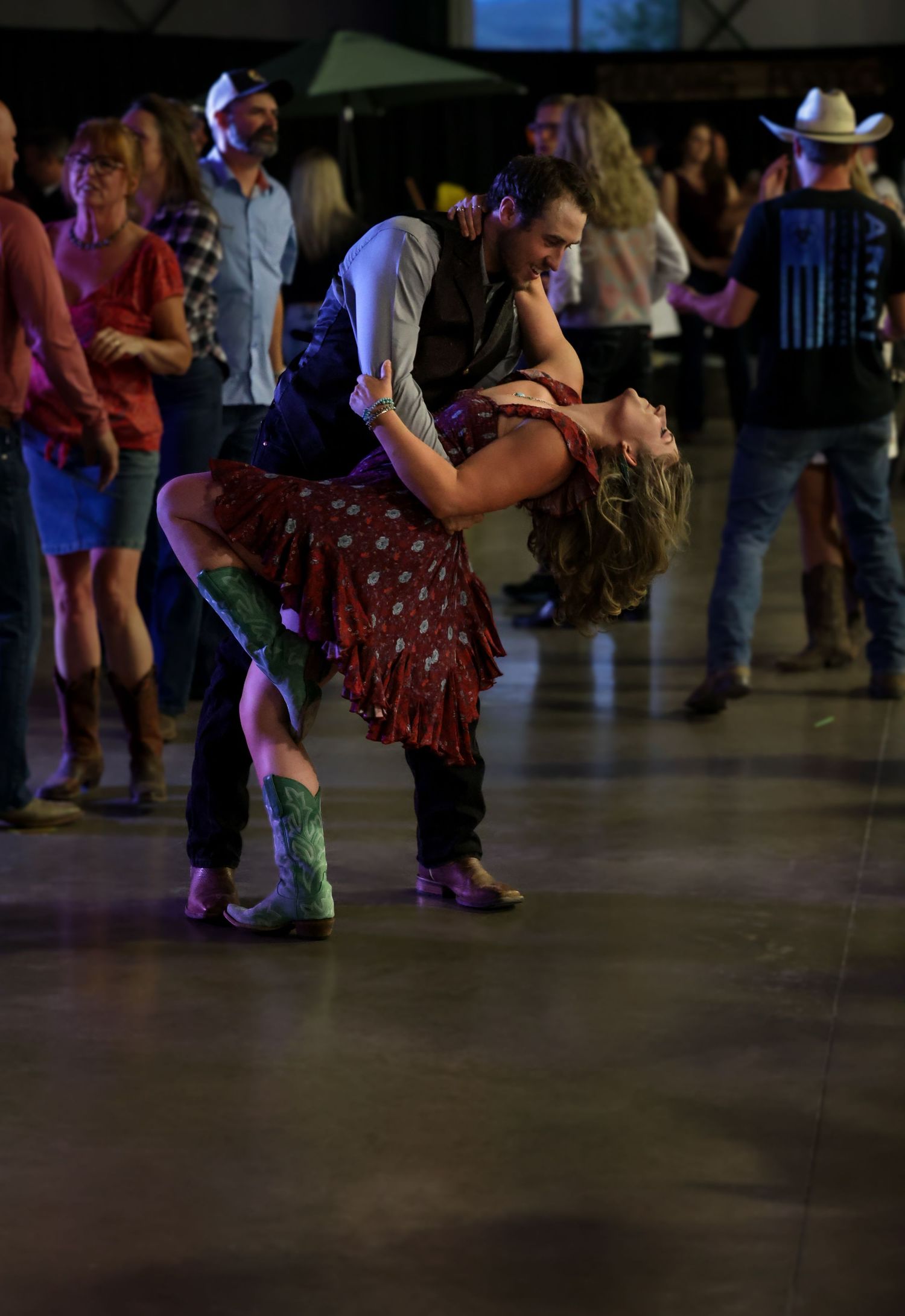 Photo of couple dancing with cowboy dressed man dipping female in an eloquent fashion.
